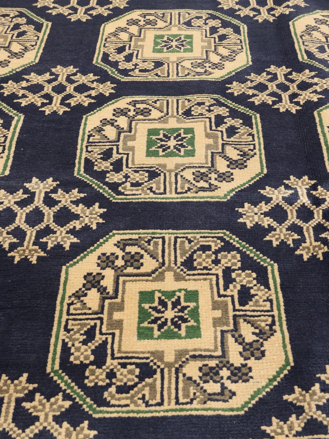 Met de hand geknoopt Afghan tapijt met een donkerblauw veld en geometrische patronen