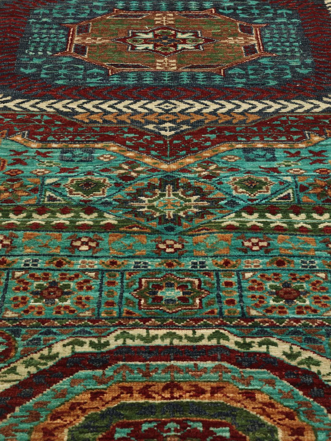 Et håndknyttet Mamluk-tæppe fra Afghanistan med dybblå og røde geometriske motiver.