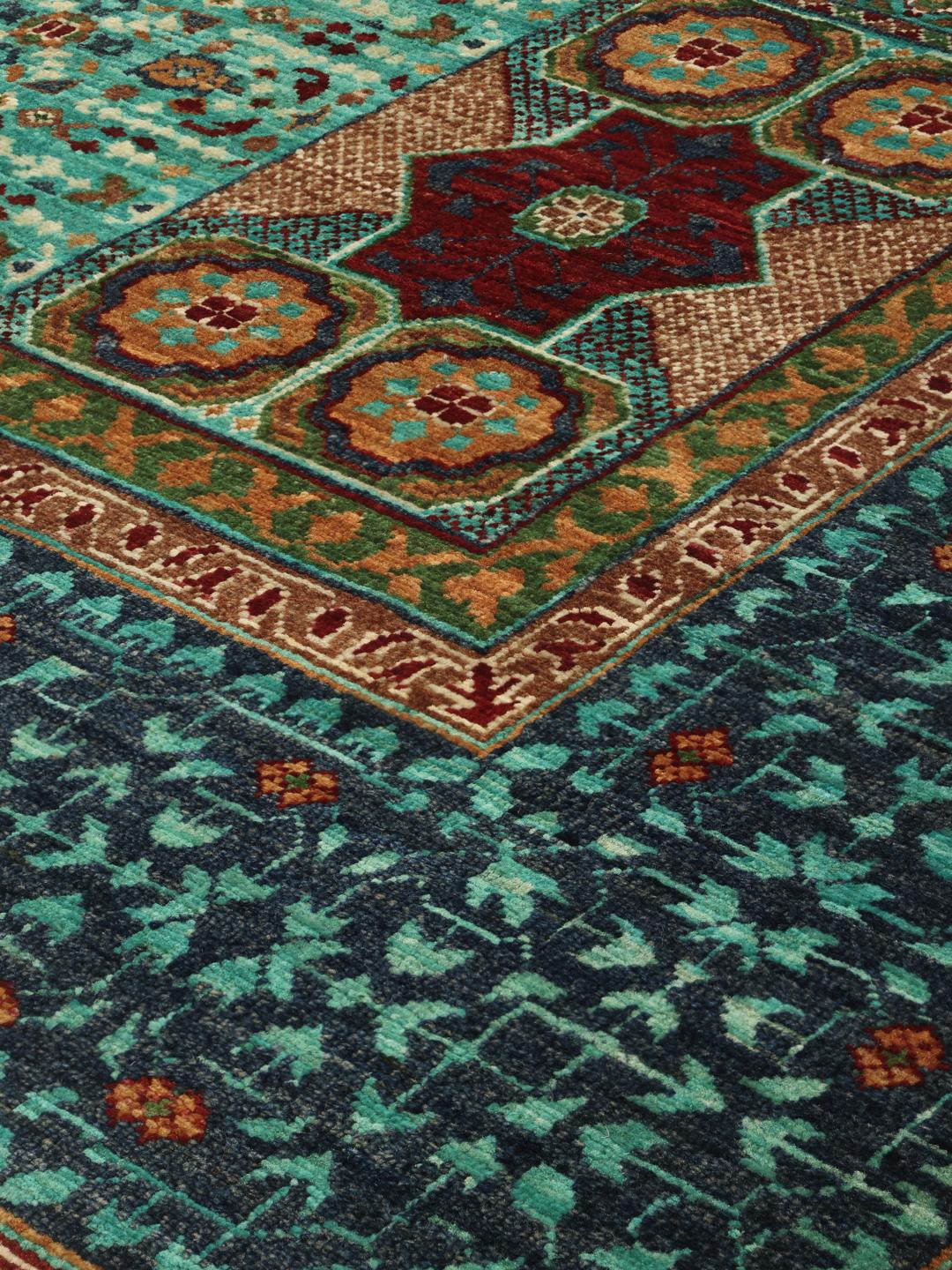 Et håndknyttet Mamluk-tæppe fra Afghanistan med dybblå og røde geometriske motiver.