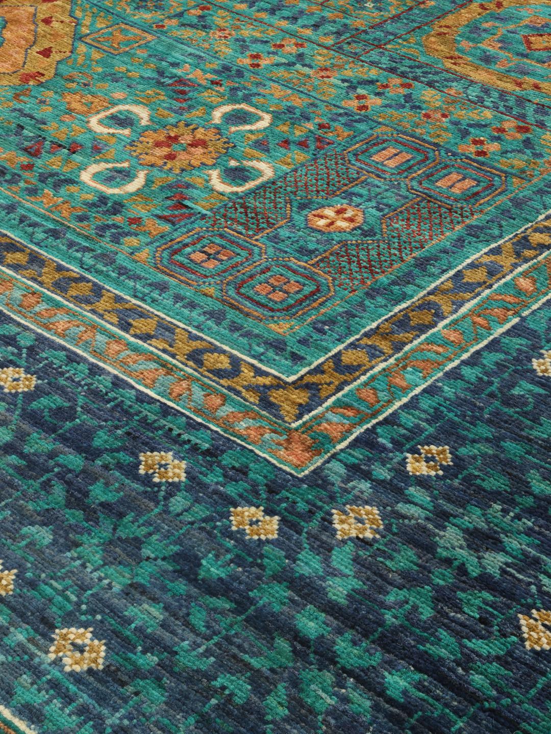 Un covor Mamluk înnodat manual din Afganistan, prezentând un câmp vibrant de culoare teal cu medalioane geometrice.