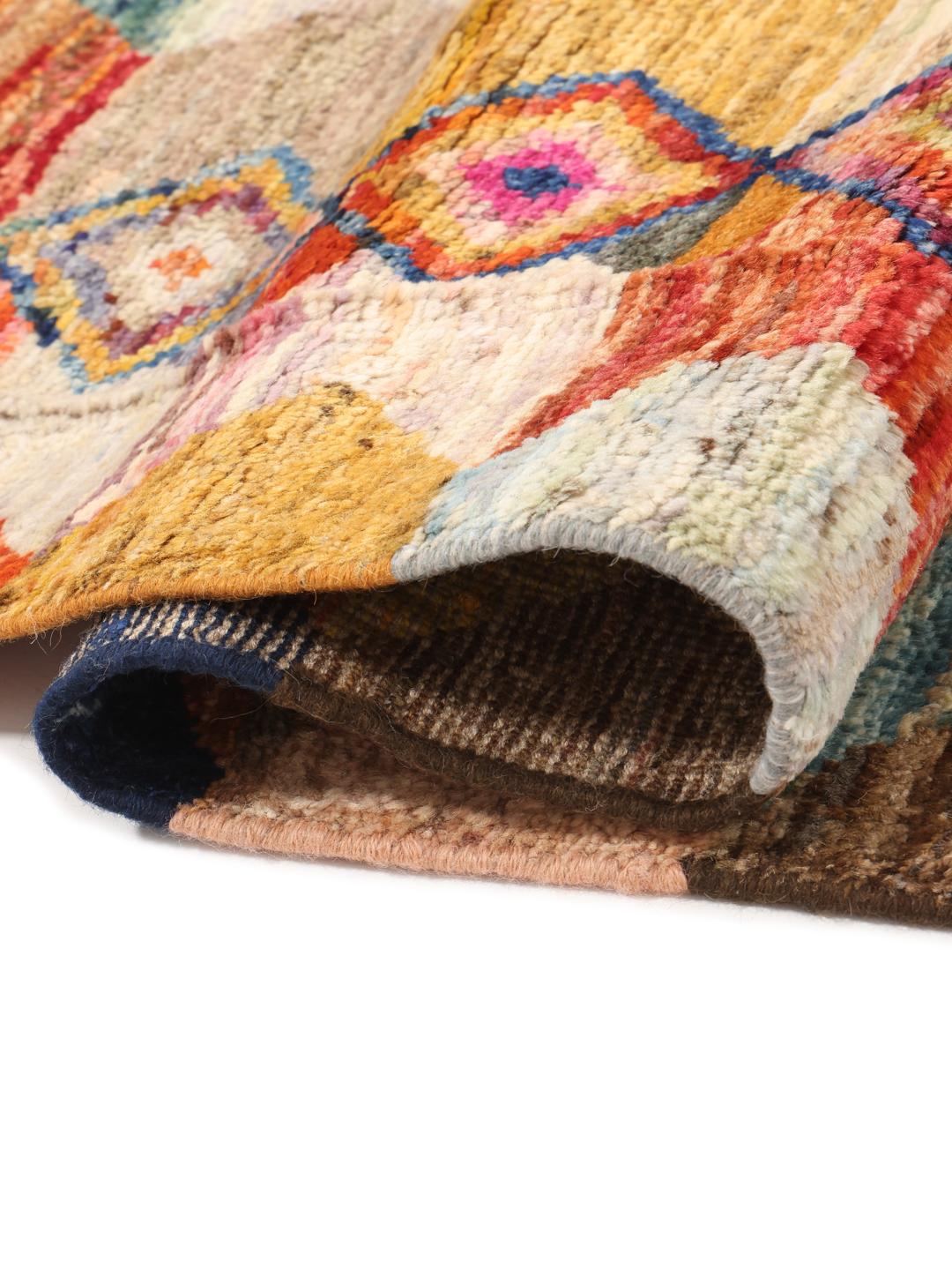 Een groot, rechthoekig, handgeknoopt Afghaans Berber-kleed met een levendig, veelkleurig chevron- en ruitpatroon.