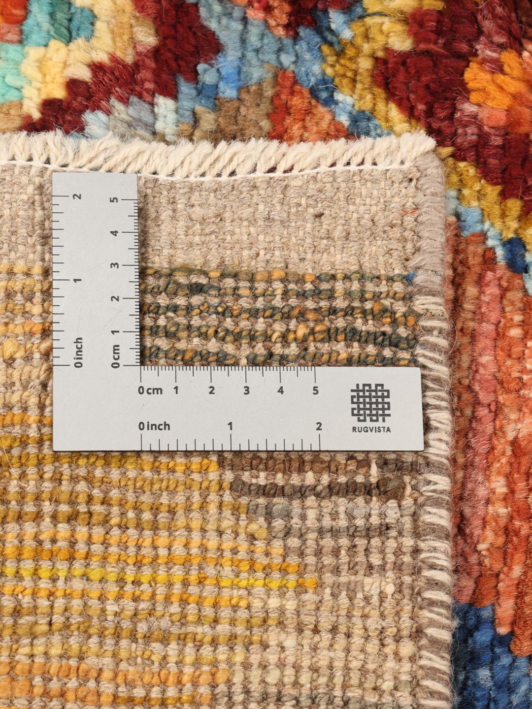 Een groot, rechthoekig, handgeknoopt Afghaans Berber-kleed met een levendig, veelkleurig chevron- en ruitpatroon.