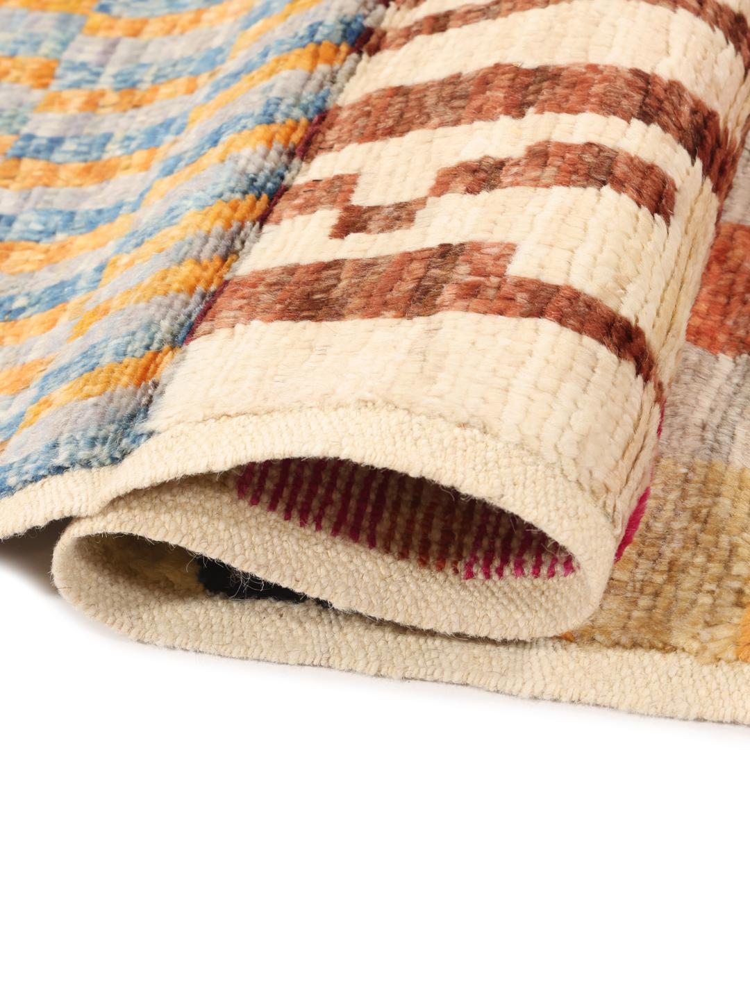 Een levendig, handgeknoopt Berber-tapijt uit Afghanistan met een veelkleurig ruitpatroon.