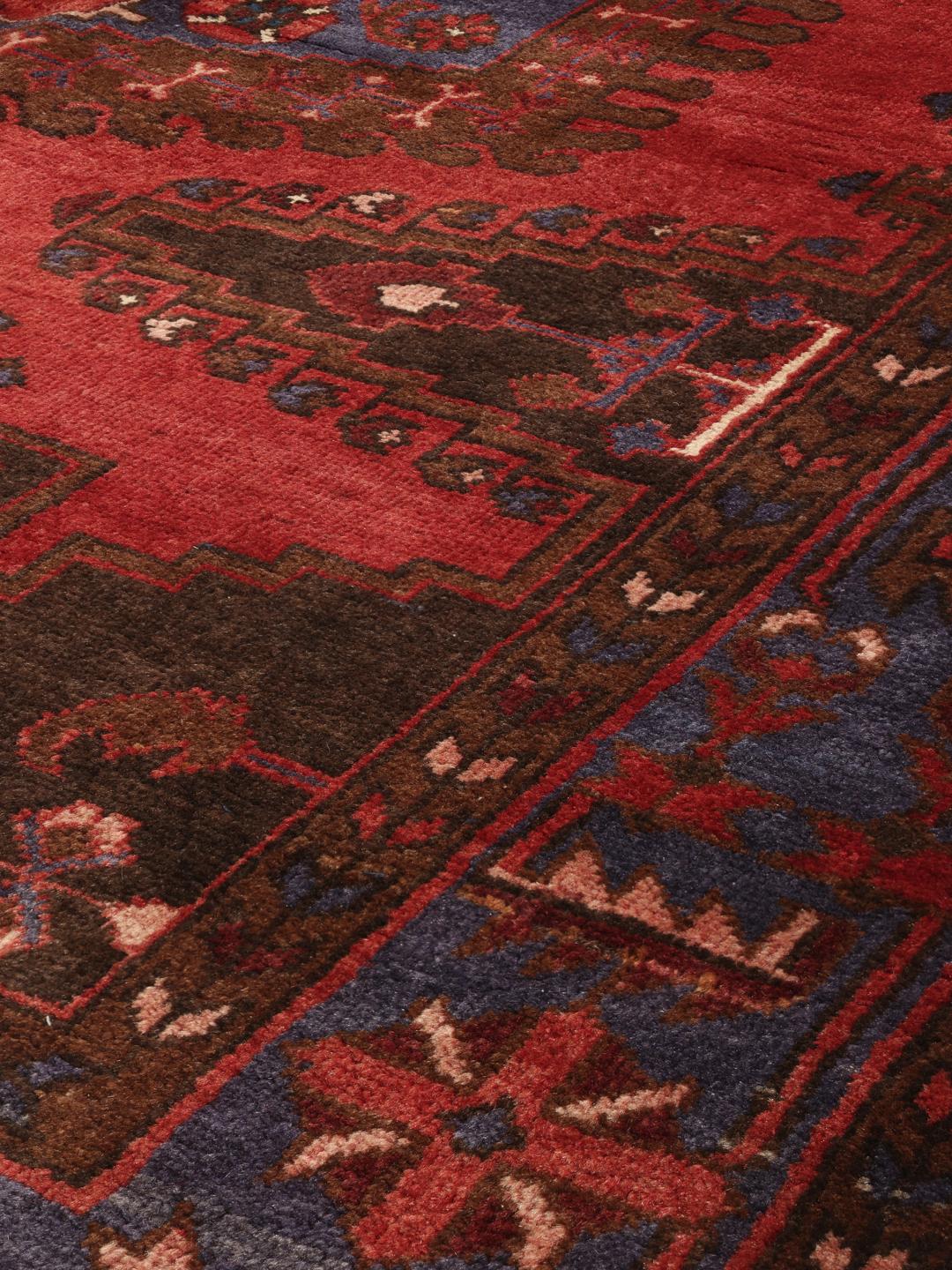 Handgeknoopt Wiss-tapijt met een traditioneel rood en blauw geometrisch patroon