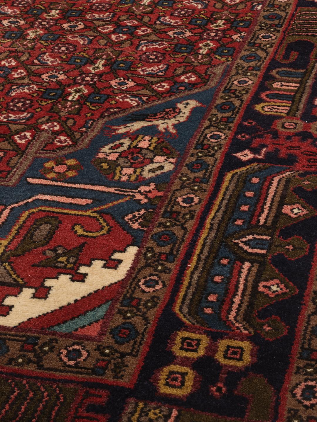 Hand-knotted Hosseinabad rug with a central medallion in red and blue tones