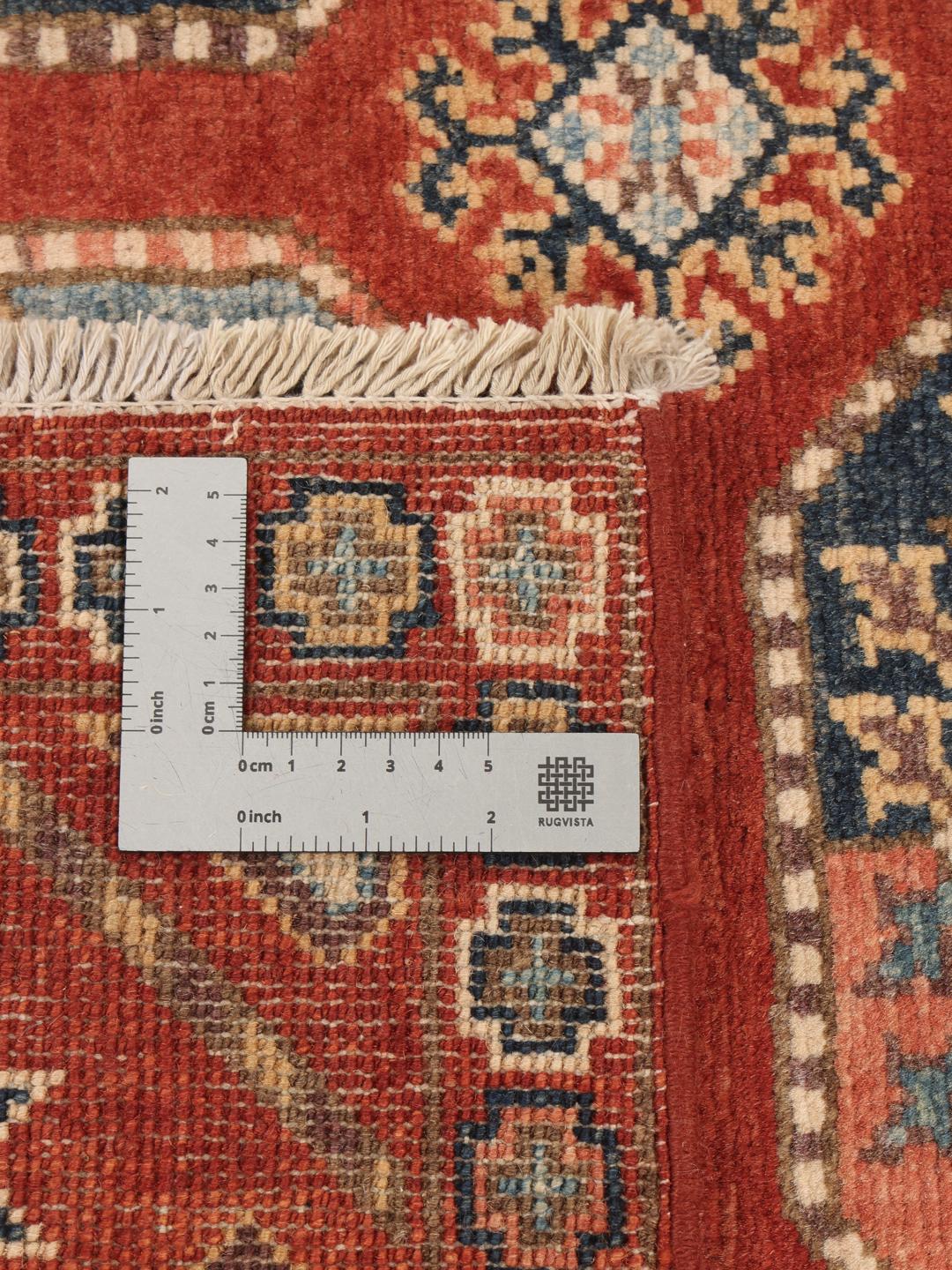 A hand-knotted Kazak rug from Afghanistan in deep red with geometric medallion motifs.