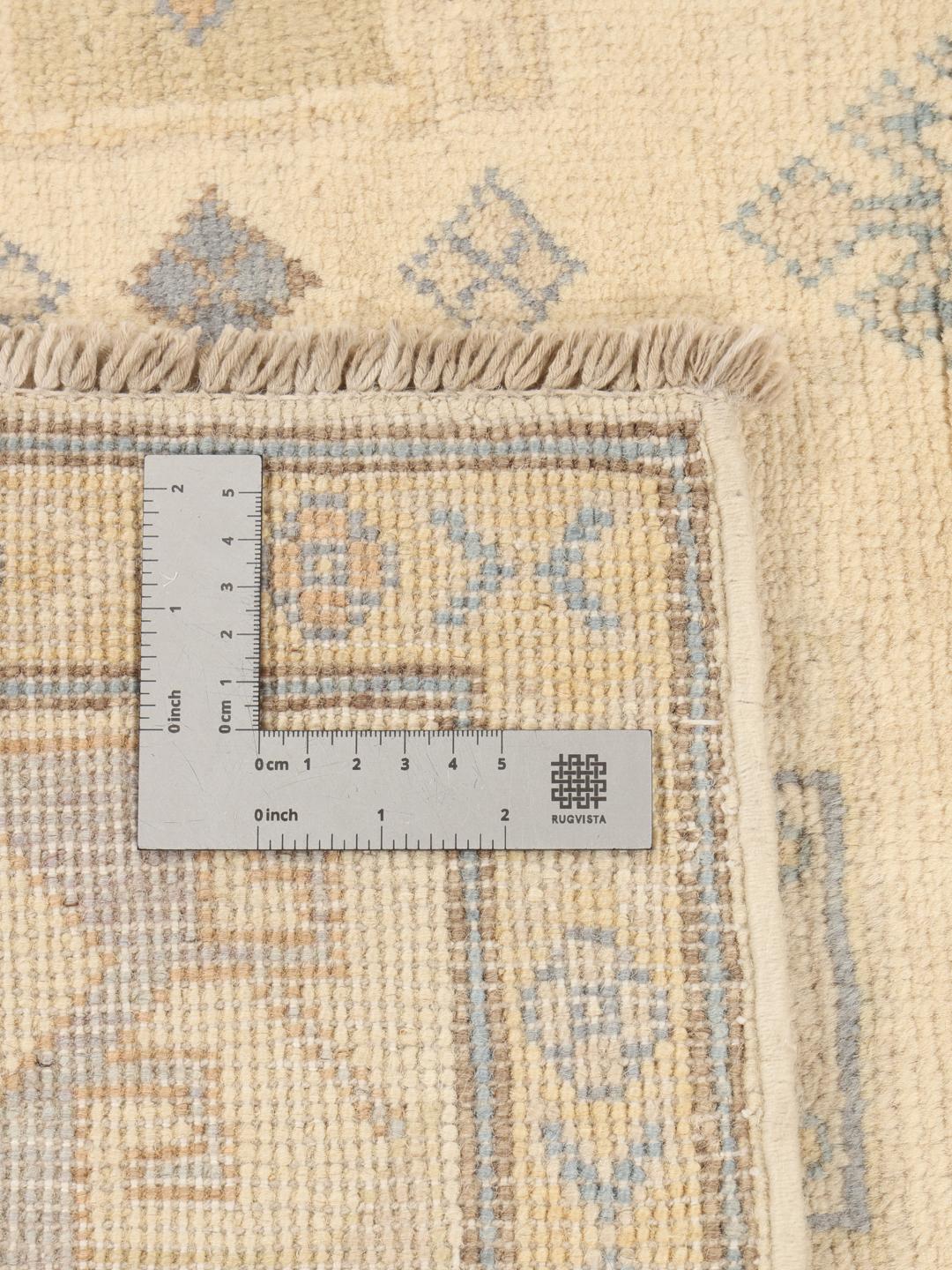 Covor Kazak înnodat manual din Afganistan cu modele geometrice bej, albastre și galbene.