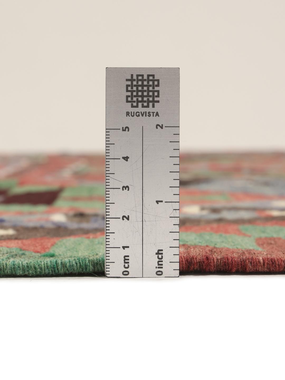 Un tapis Kelim turc vintage présentant un motif géométrique vibrant dans des tons de rouge, vert et bleu.