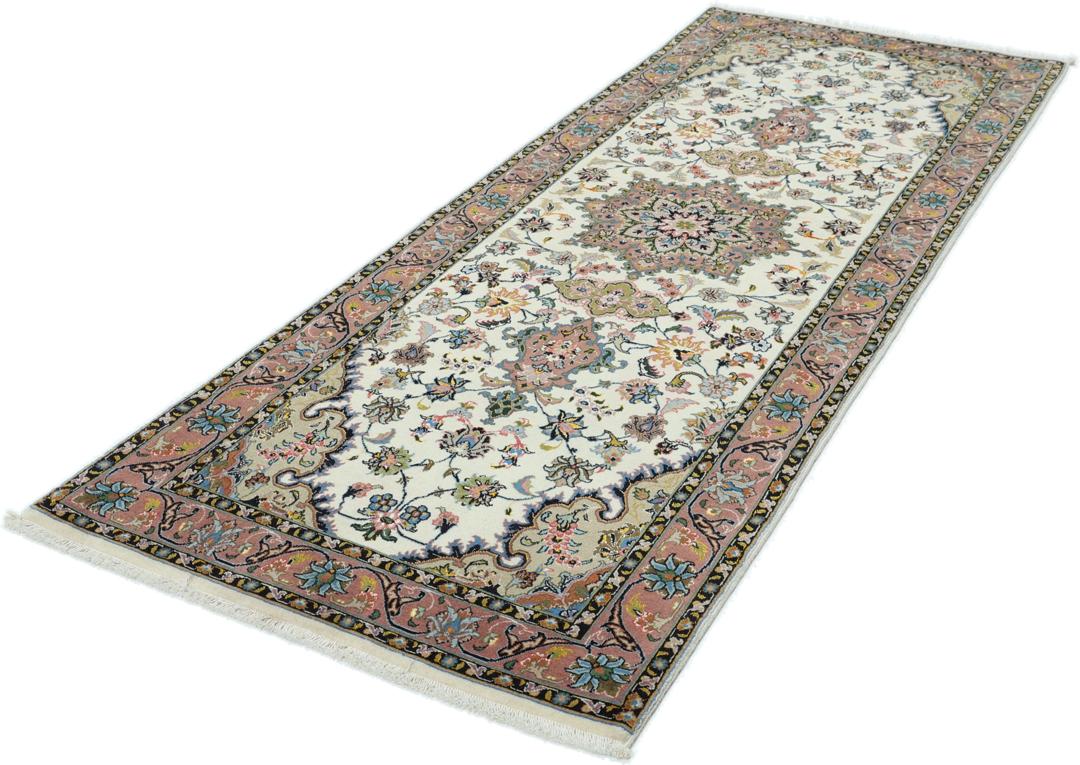 En håndknyttet Tabriz-løber med indviklede blomstermønstre i rød og beige på en cremefarvet baggrund