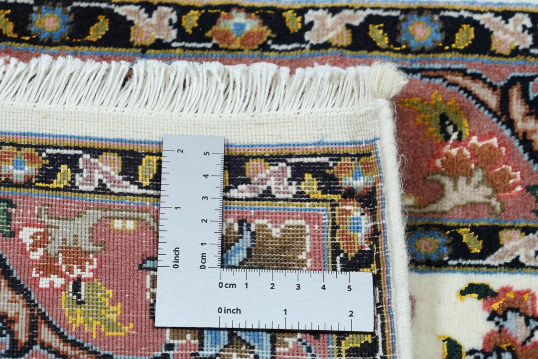 En håndknyttet Tabriz-løber med indviklede blomstermønstre i rød og beige på en cremefarvet baggrund