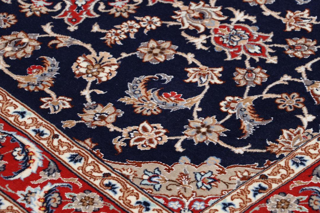 Een handgeknoopte Isfahan loper met een donkerblauw veld en rode bloemenranden.