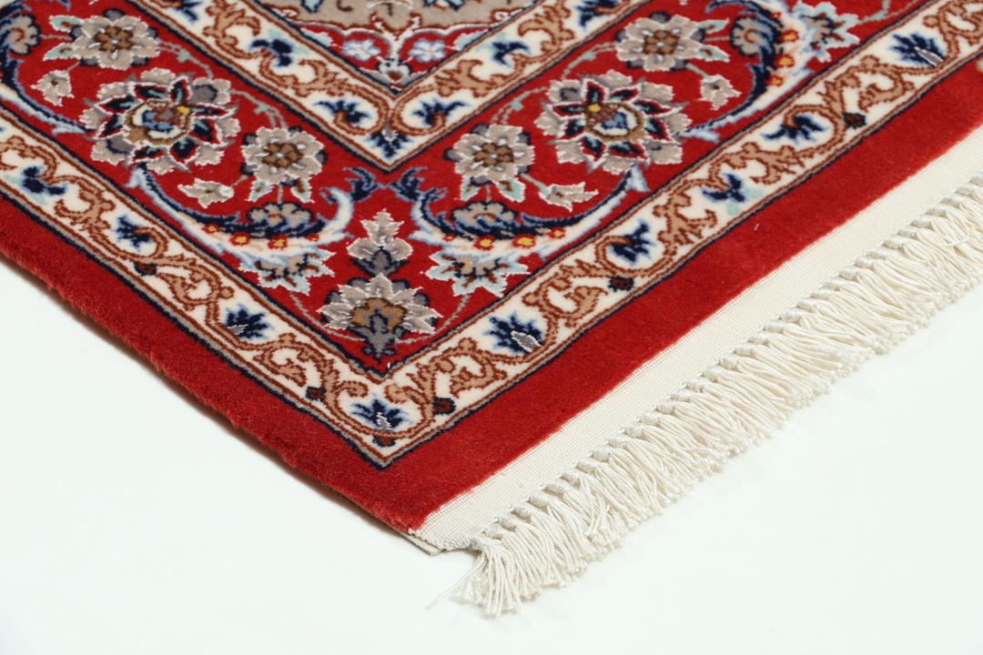 Een handgeknoopte Isfahan loper met een donkerblauw veld en rode bloemenranden.
