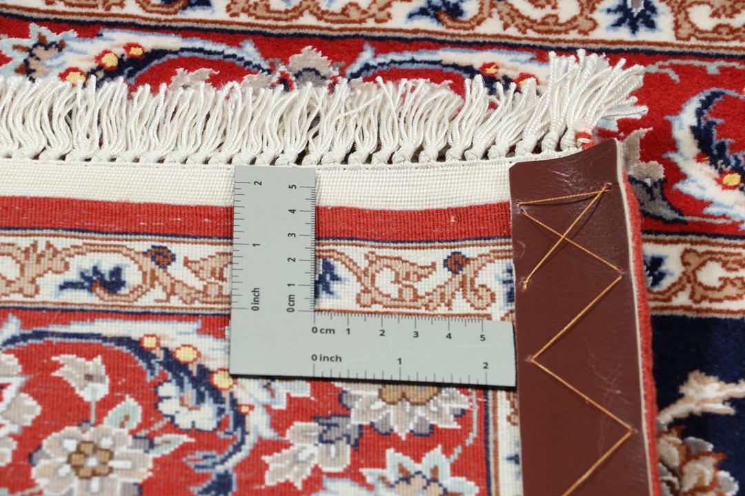 Een handgeknoopte Isfahan loper met een donkerblauw veld en rode bloemenranden.