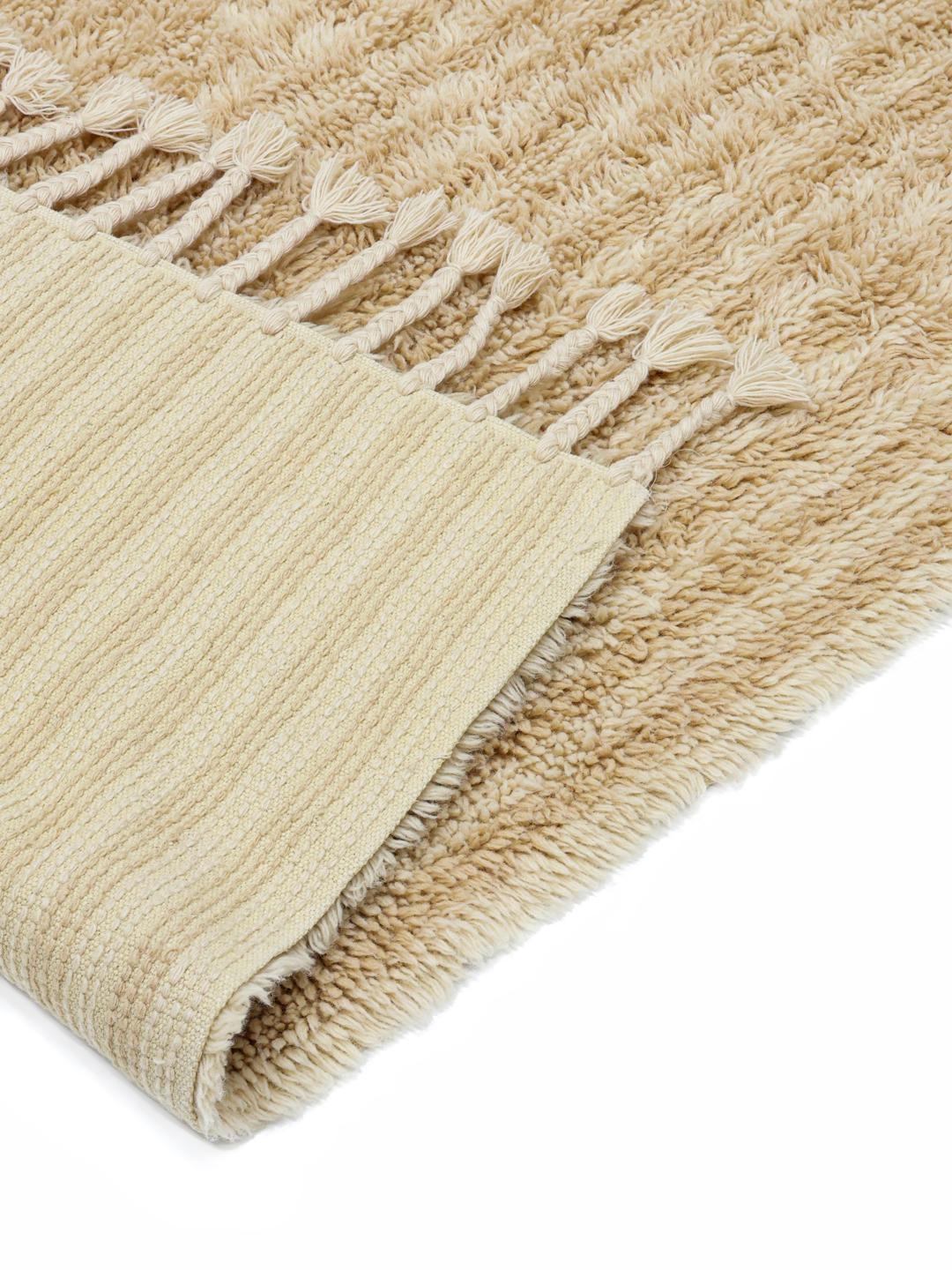 Beige tæppe med riflet tekstur og frynser