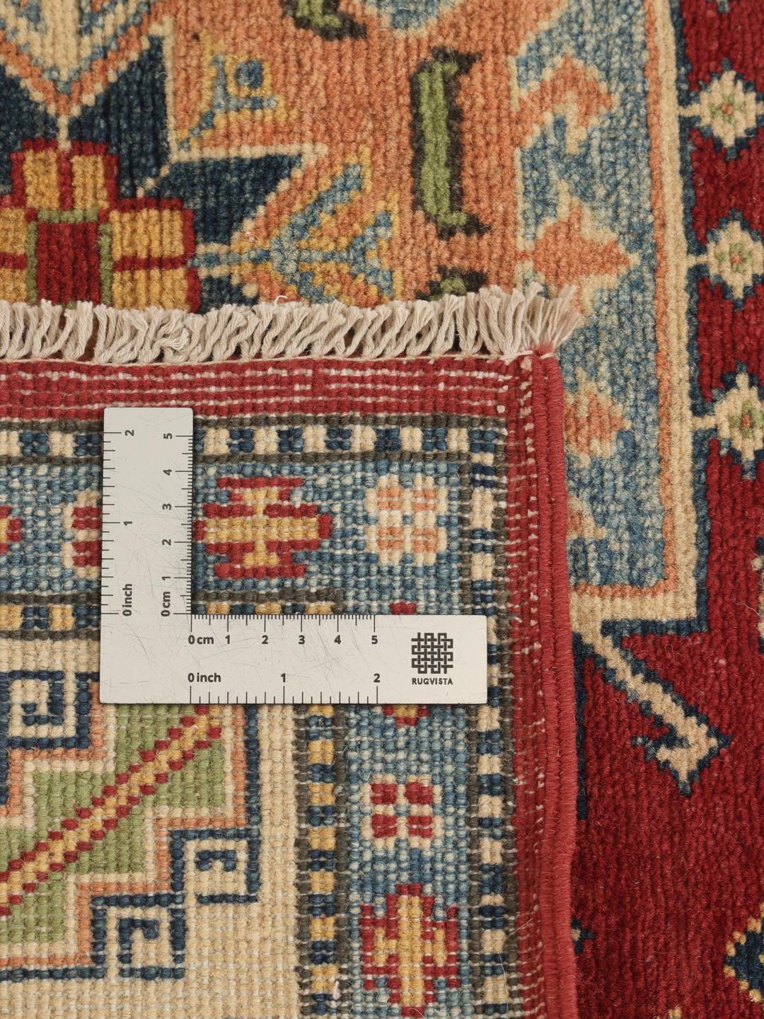 Een handgeknoopt Kazak-tapijt uit Afghanistan met een rood veld en geometrische medaillons.