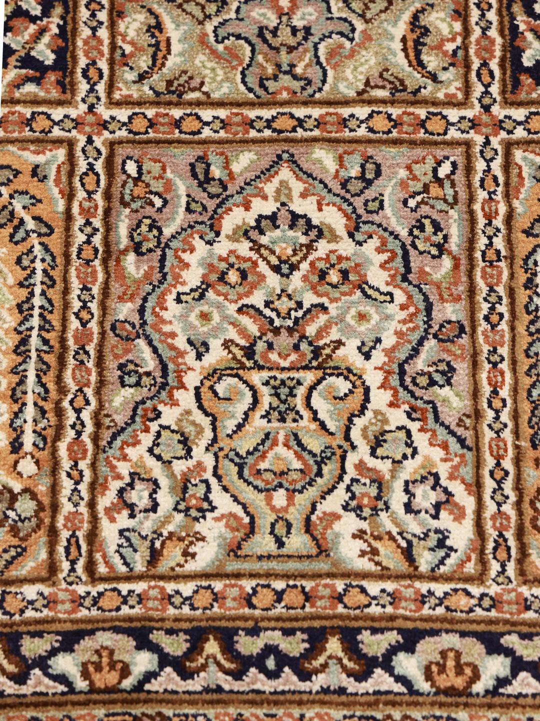 Et luksuriøst håndknyttet indisk silketæppe med et gittermønstret havedesign i beige og blå toner.