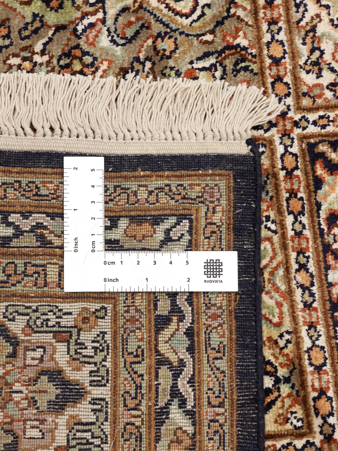Et luksuriøst håndknyttet indisk silketæppe med et gittermønstret havedesign i beige og blå toner.