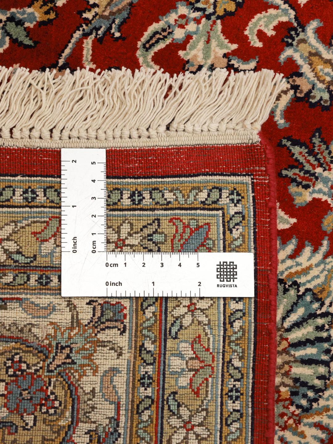 Et luksuriøst håndknyttet indisk Kashmir-silketæppe med et indviklet blomstermønster i røde og beige nuancer.
