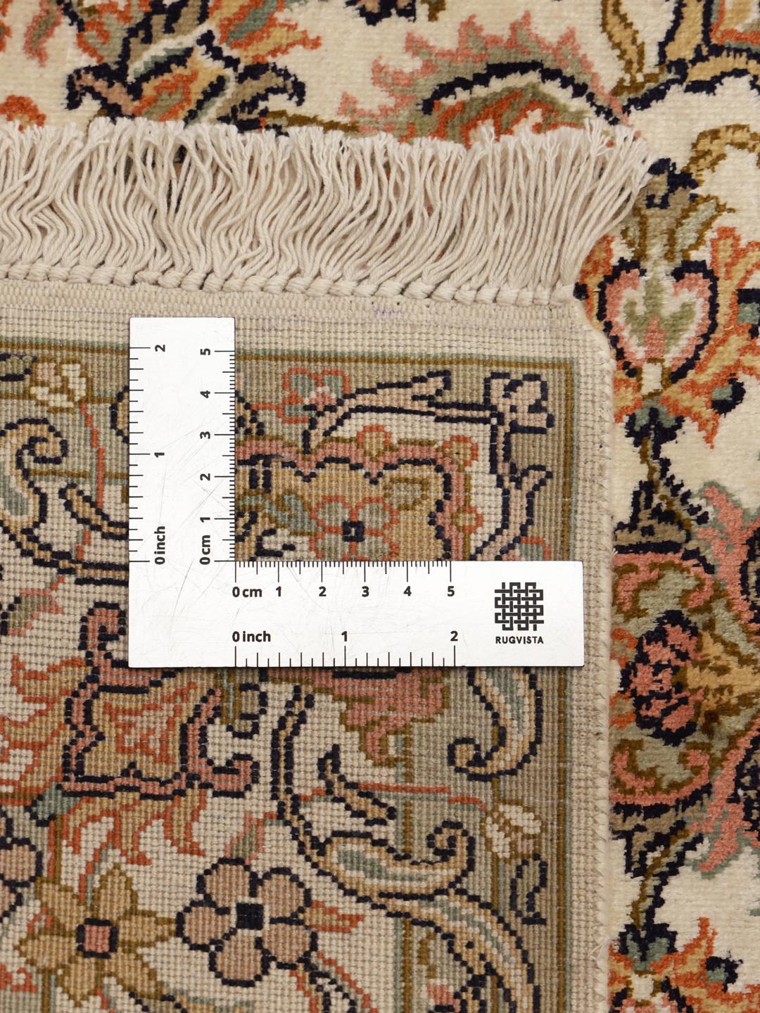 Et luksuriøst håndknyttet Kashmir-silketæppe fra Indien med et fint blomstermønster i beige toner.