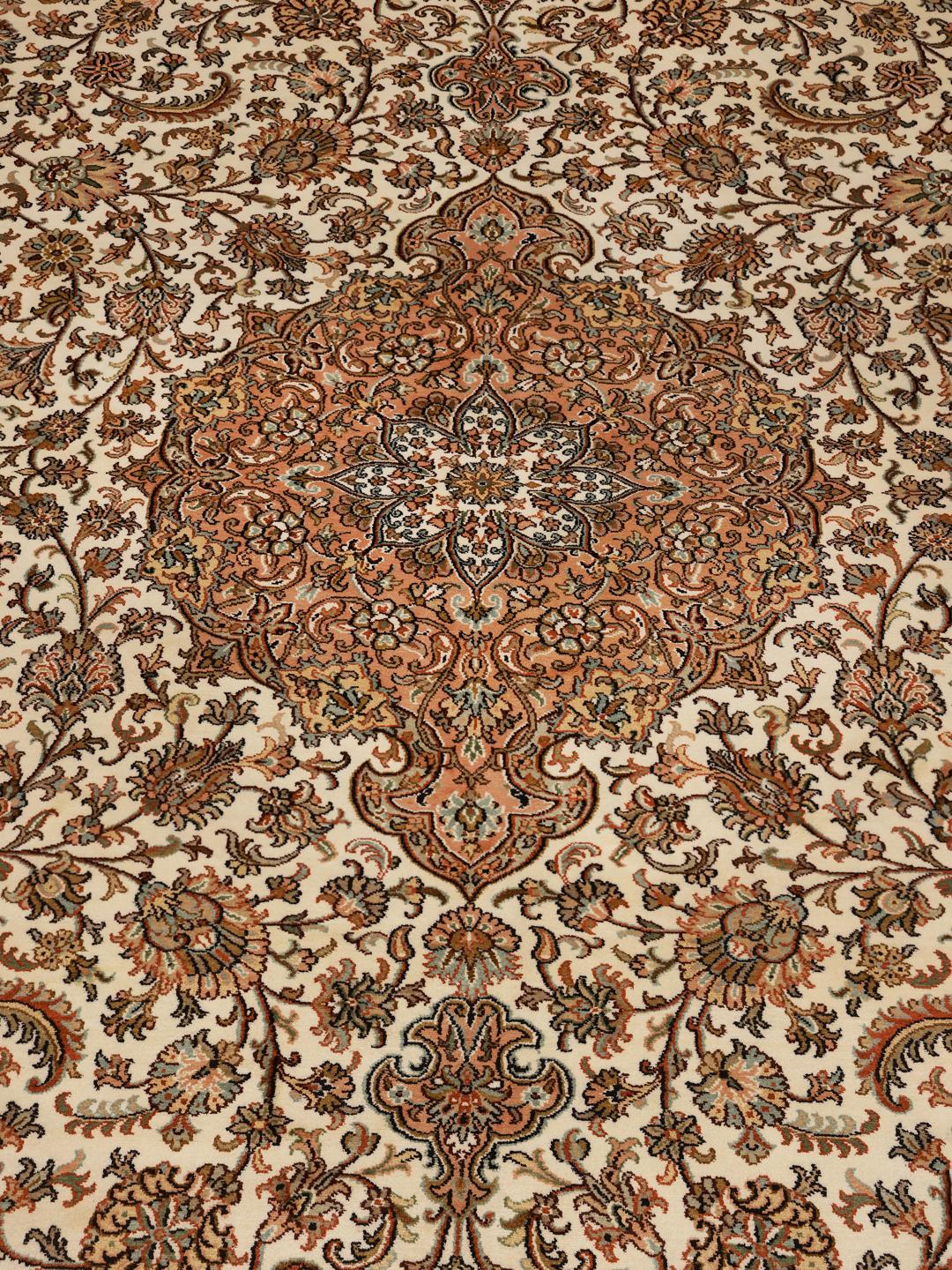 A hand-knotted Indian Kashmir silk rug with an intricate beige and floral pattern.