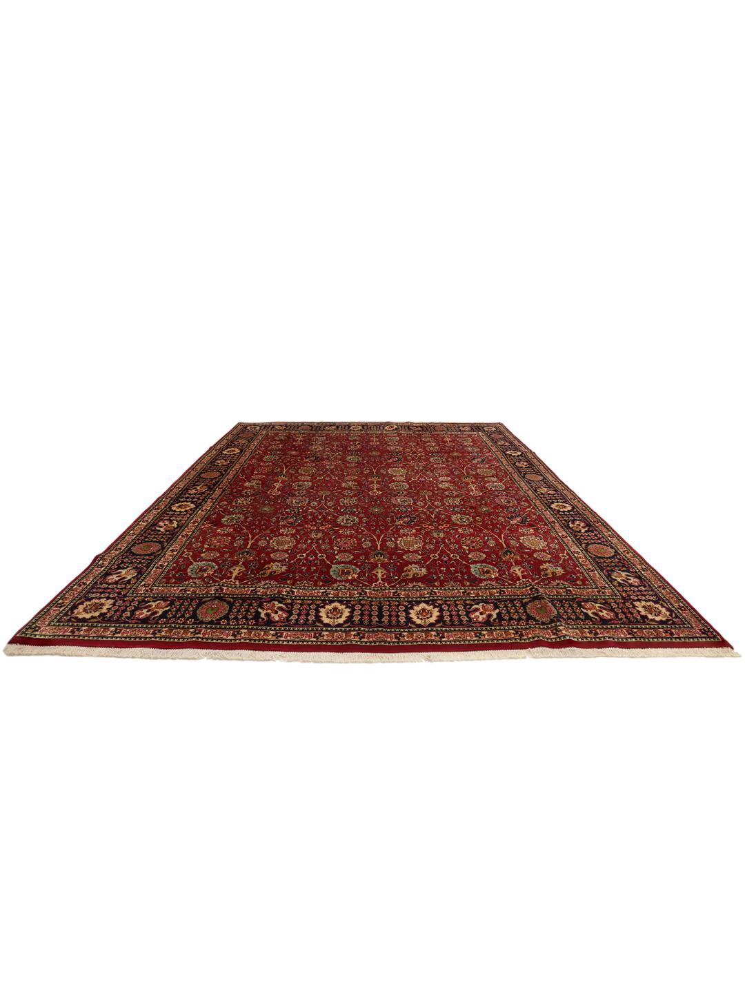 A large rectangular Tabriz rug with a deep red field and intricate floral patterns.