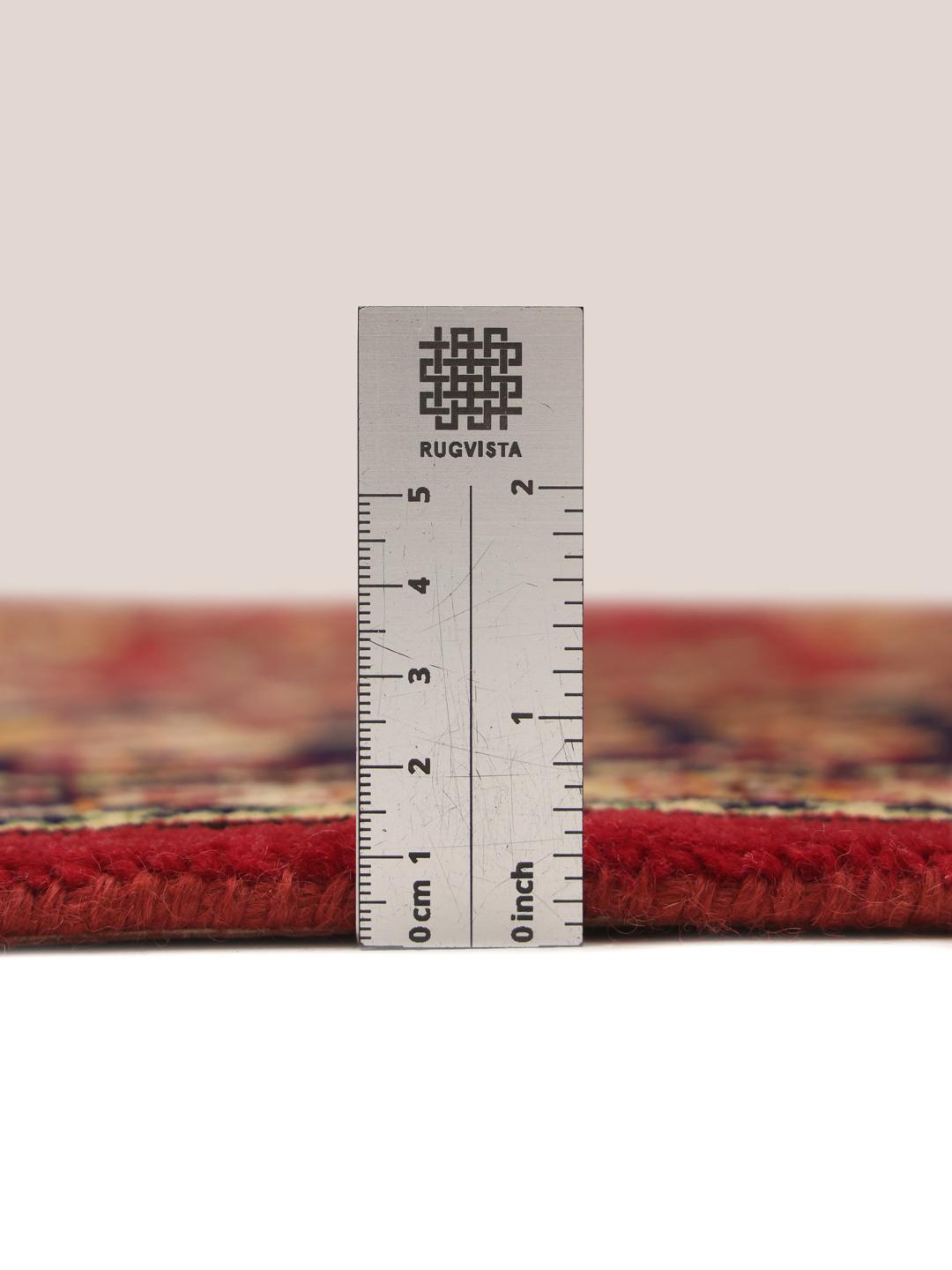 A large rectangular Tabriz rug with a deep red field and intricate floral patterns.