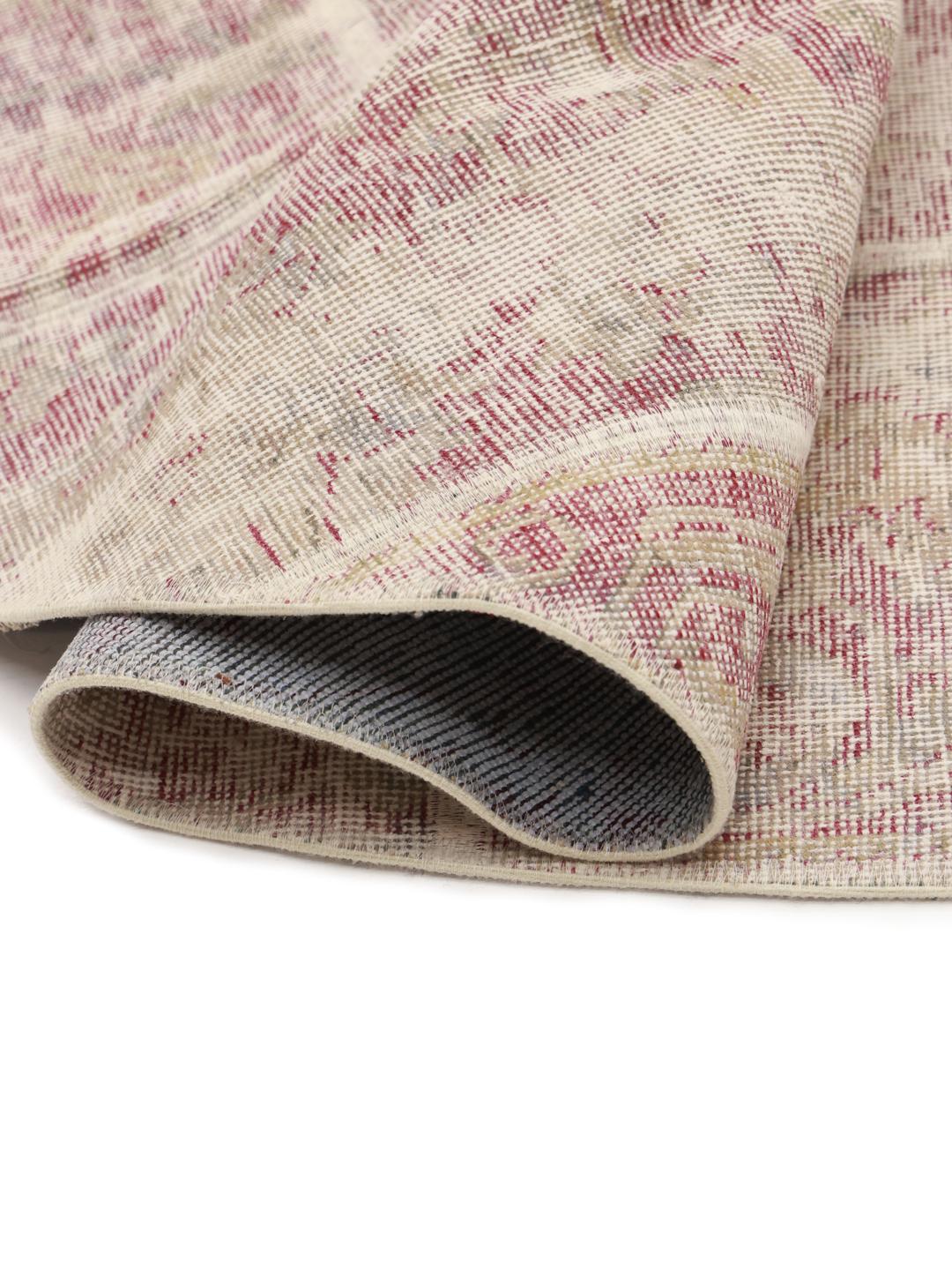 Rundt patchworktæppe med beige og dæmpede røde toner fra Mellemøsten.