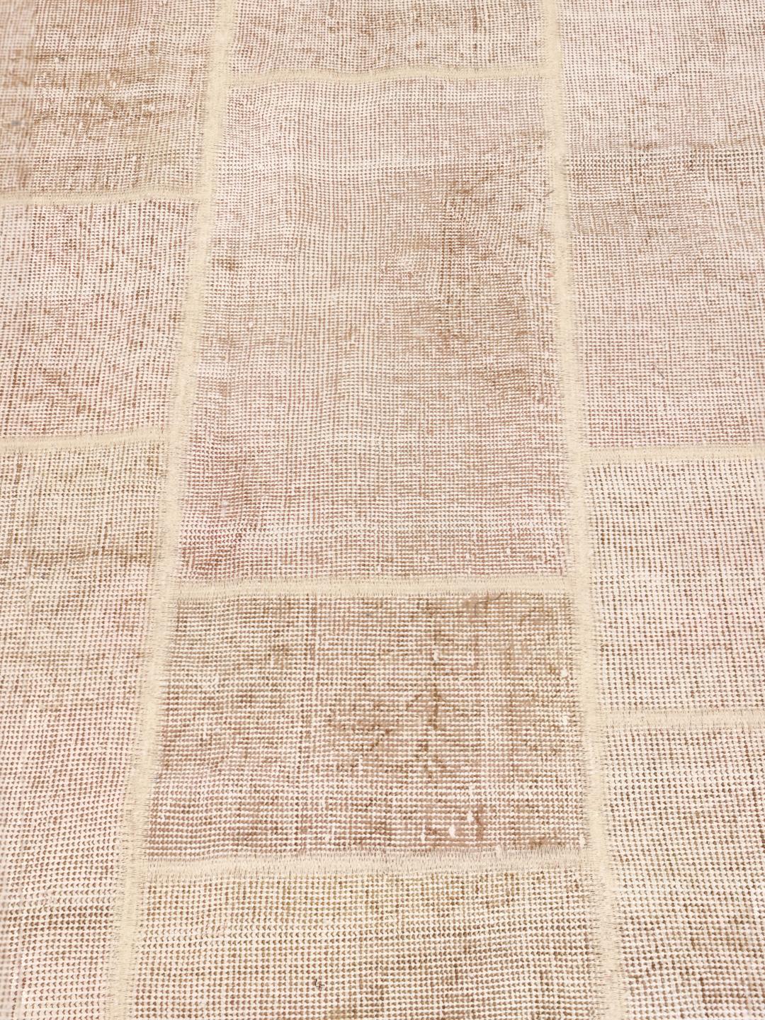 Et neutralt beige patchwork uldtæppe med et rektangulært gittermønster fra Mellemøsten.