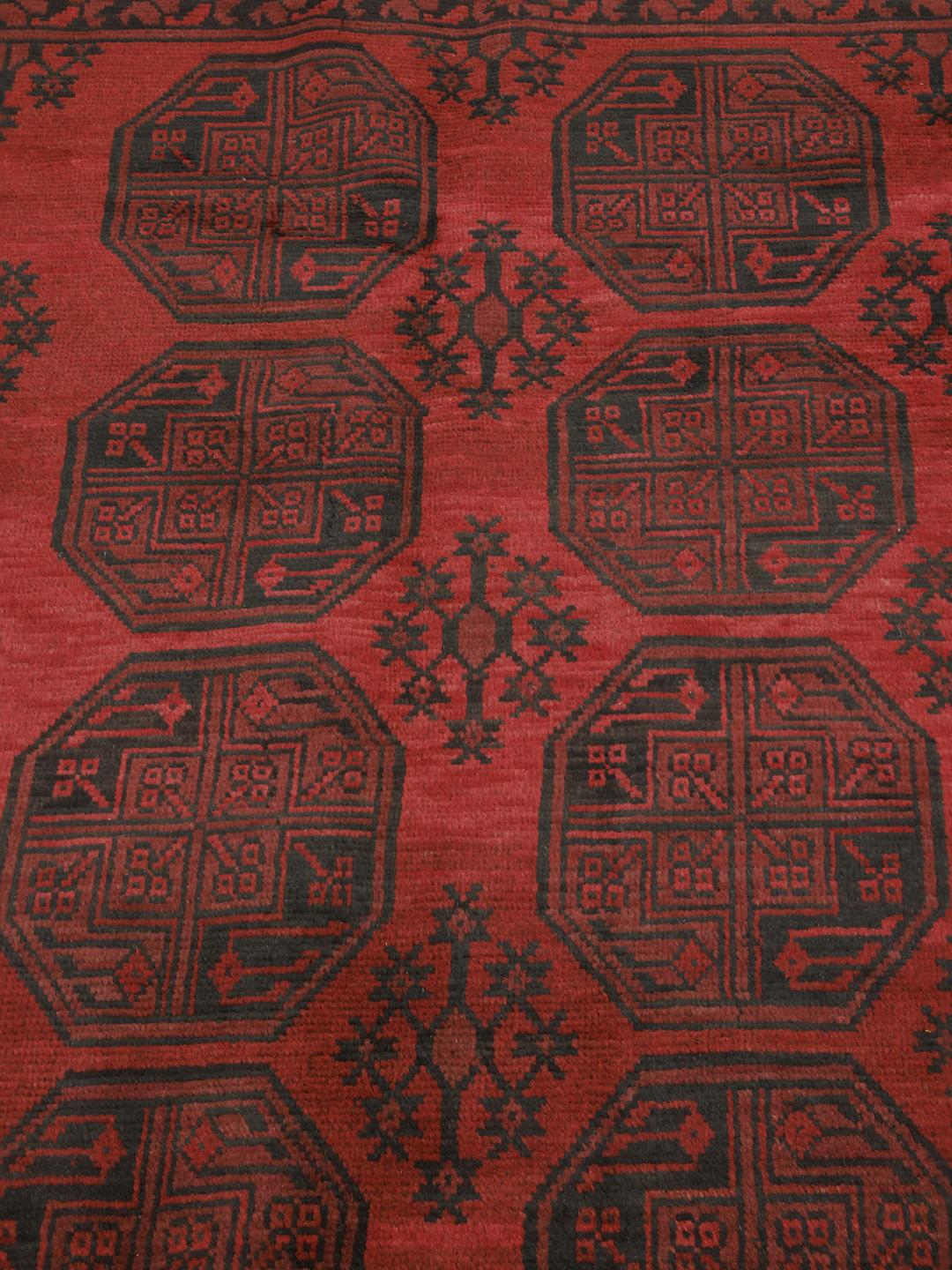 Håndknyttet Afghan Akhche-tæppe med en dyb rød bund og mørke geometriske motiver