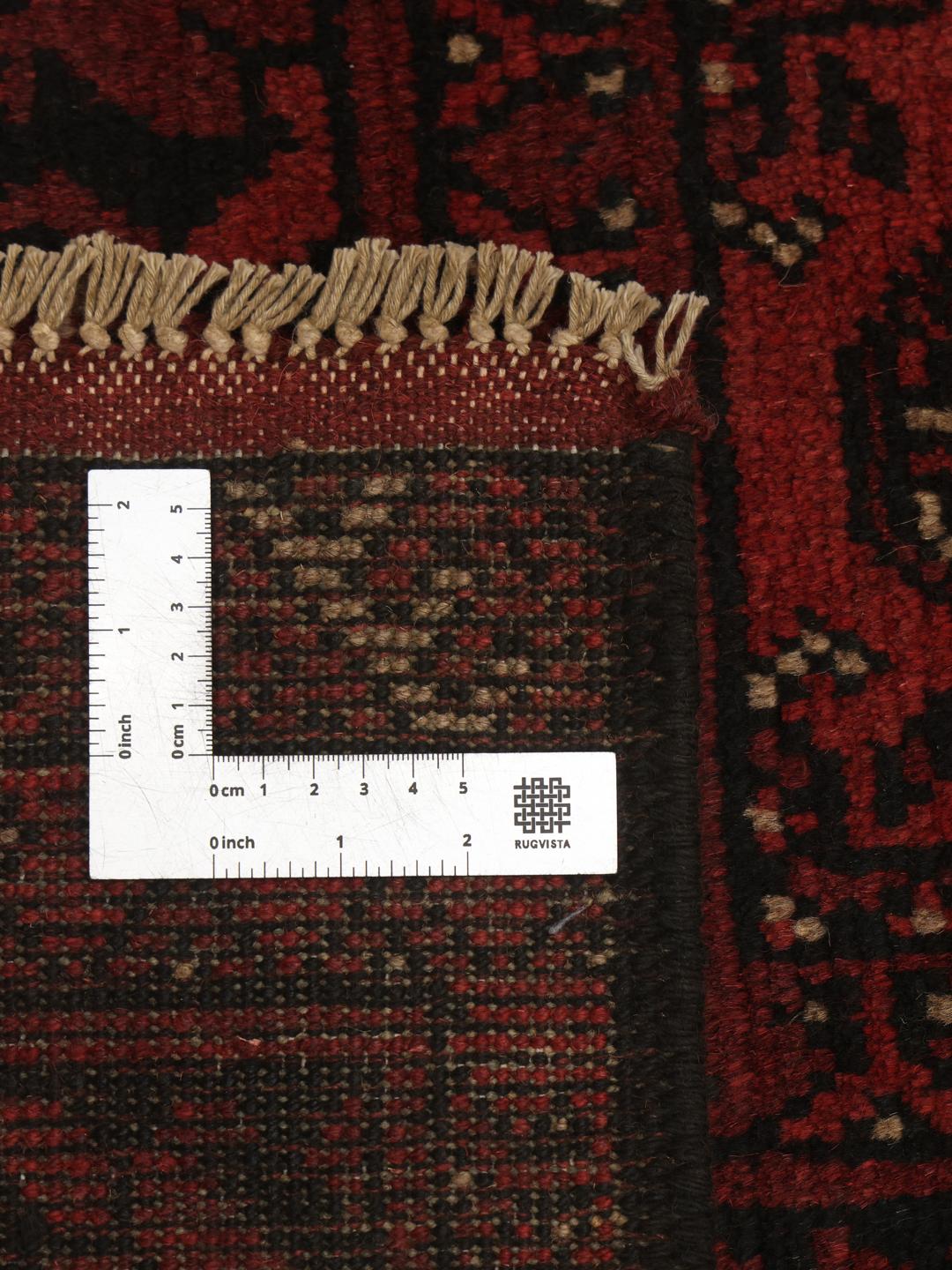 Håndknyttet afghansk tæppe med en dyb rød bund og geometriske motiver