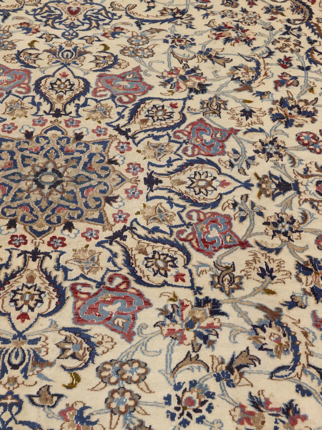 Hand-knotted Middle Eastern rug with intricate floral patterns in beige and blue