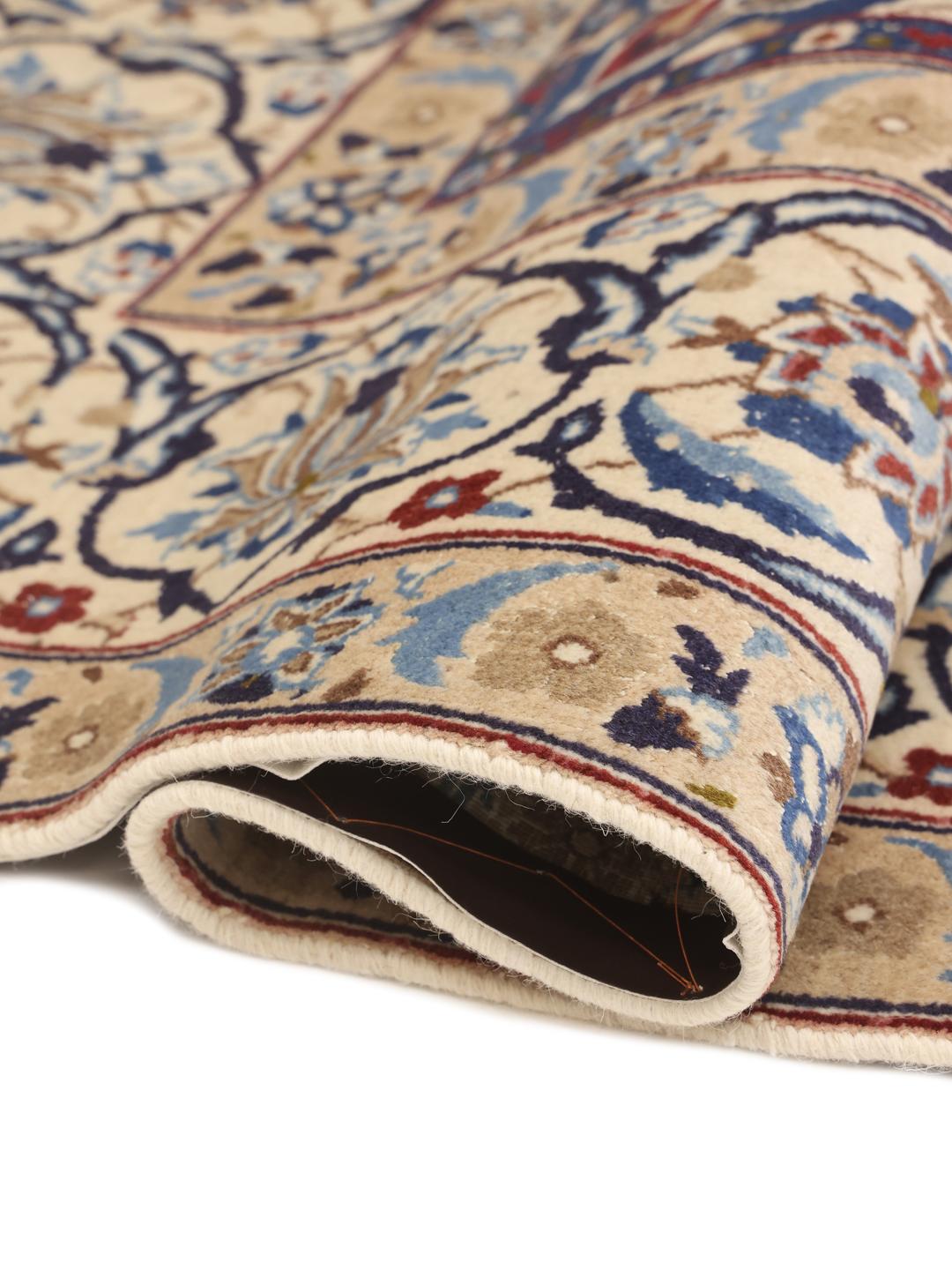Hand-knotted Middle Eastern rug with intricate floral patterns in beige and blue