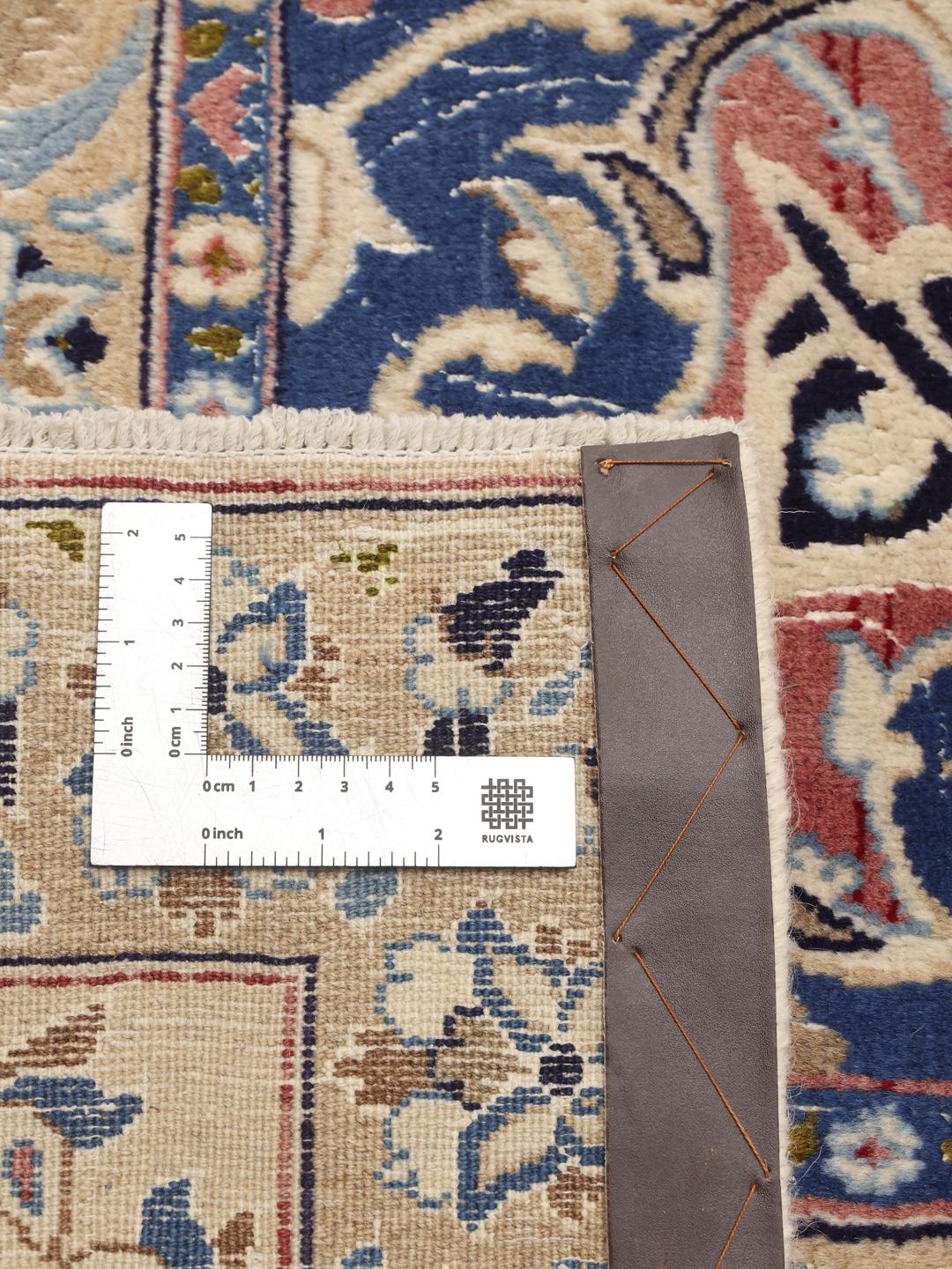 Hand-knotted Middle Eastern rug with intricate floral patterns in beige and blue