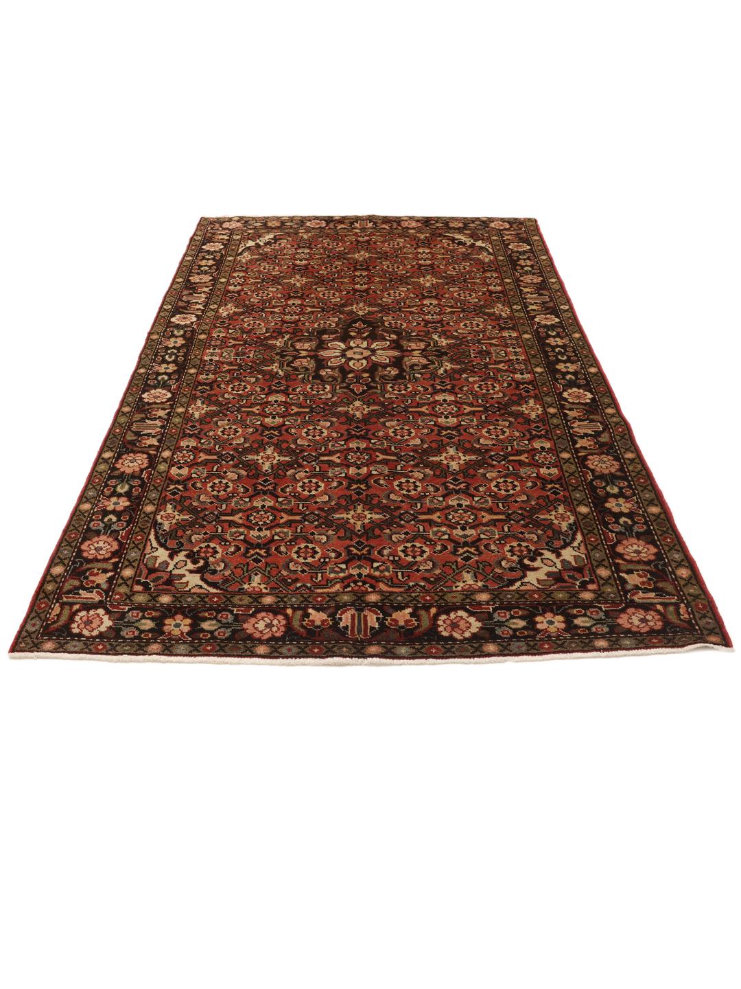 A hand-knotted Hosseinabad rug from the Middle East featuring a red and dark-toned floral design