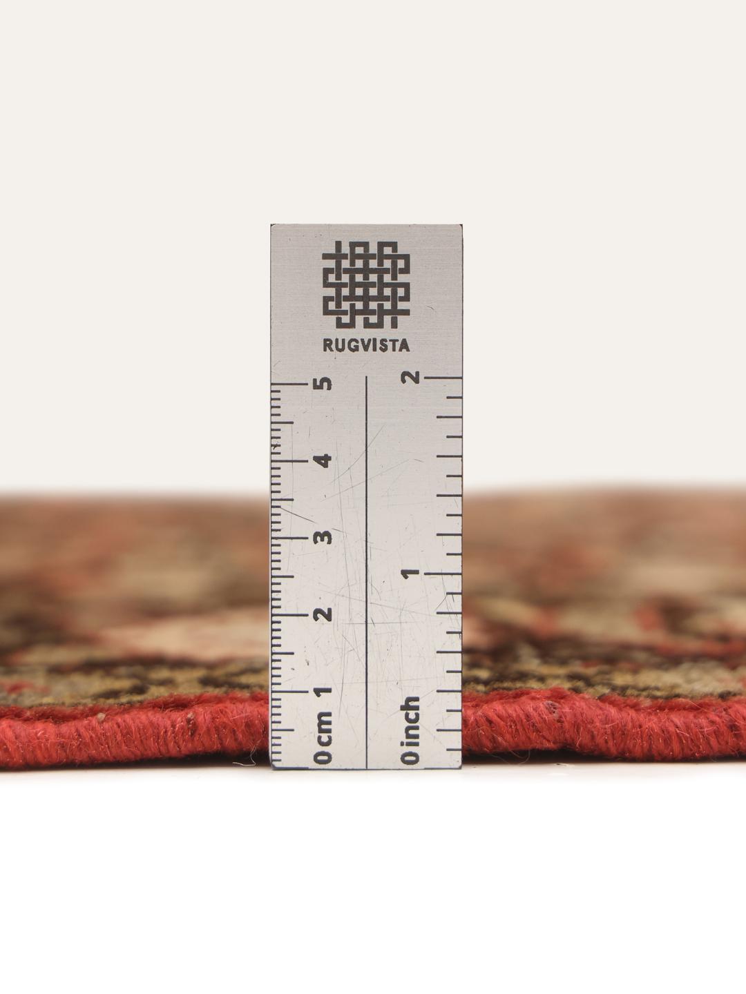 A hand-knotted Hosseinabad rug from the Middle East featuring a red and dark-toned floral design