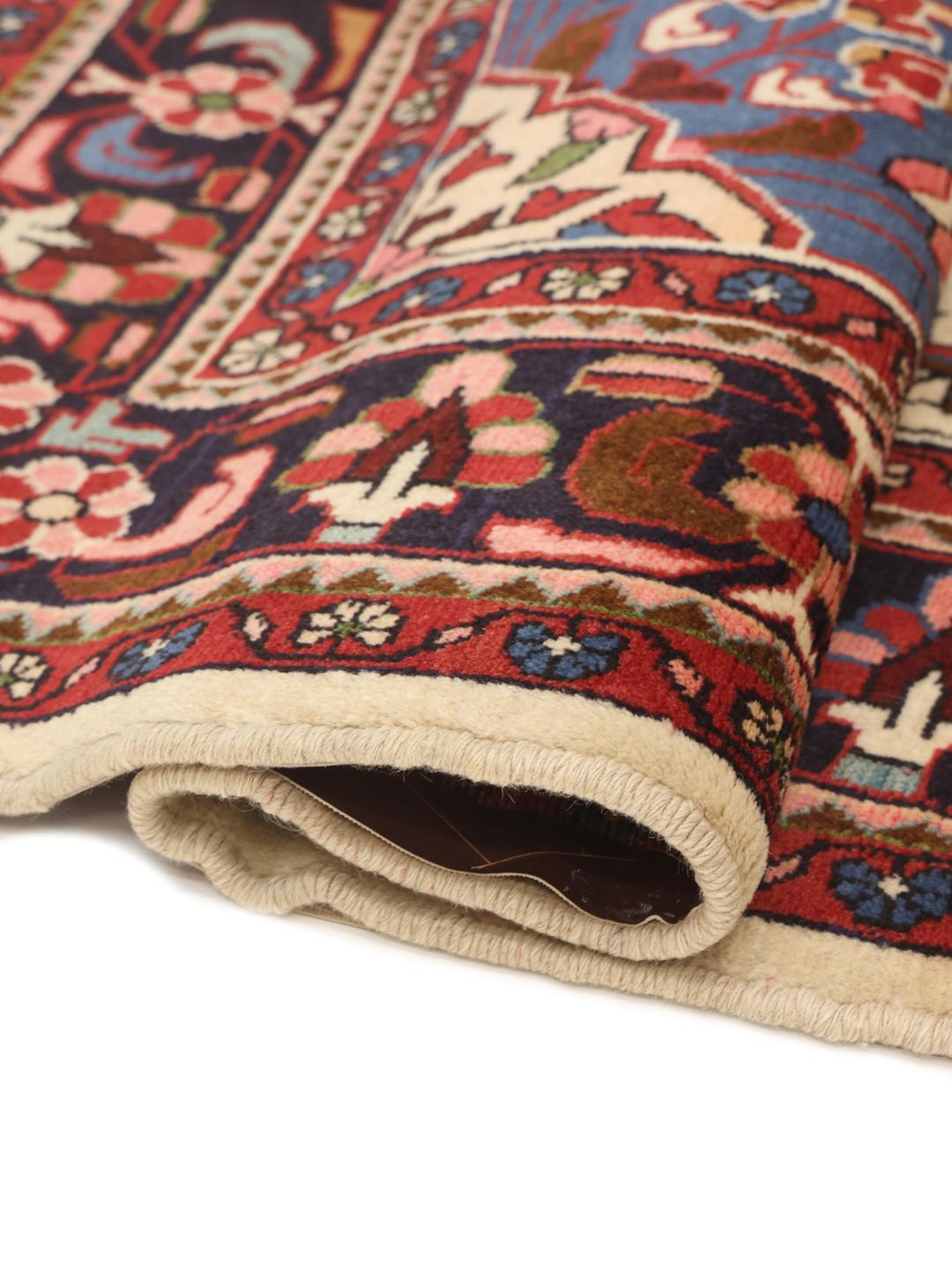 Handgemaakt Lillian-tapijt met een centraal medaillon en bloemmotieven in beige, blauwe en rode tinten