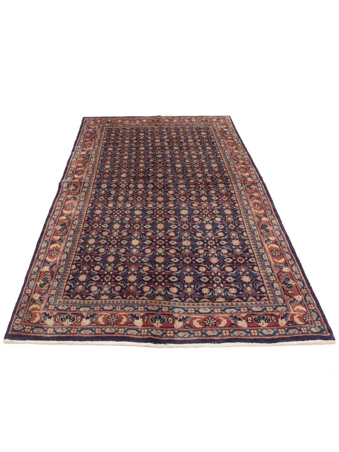 A hand-knotted Sarough rug from the Middle East with a deep blue floral pattern