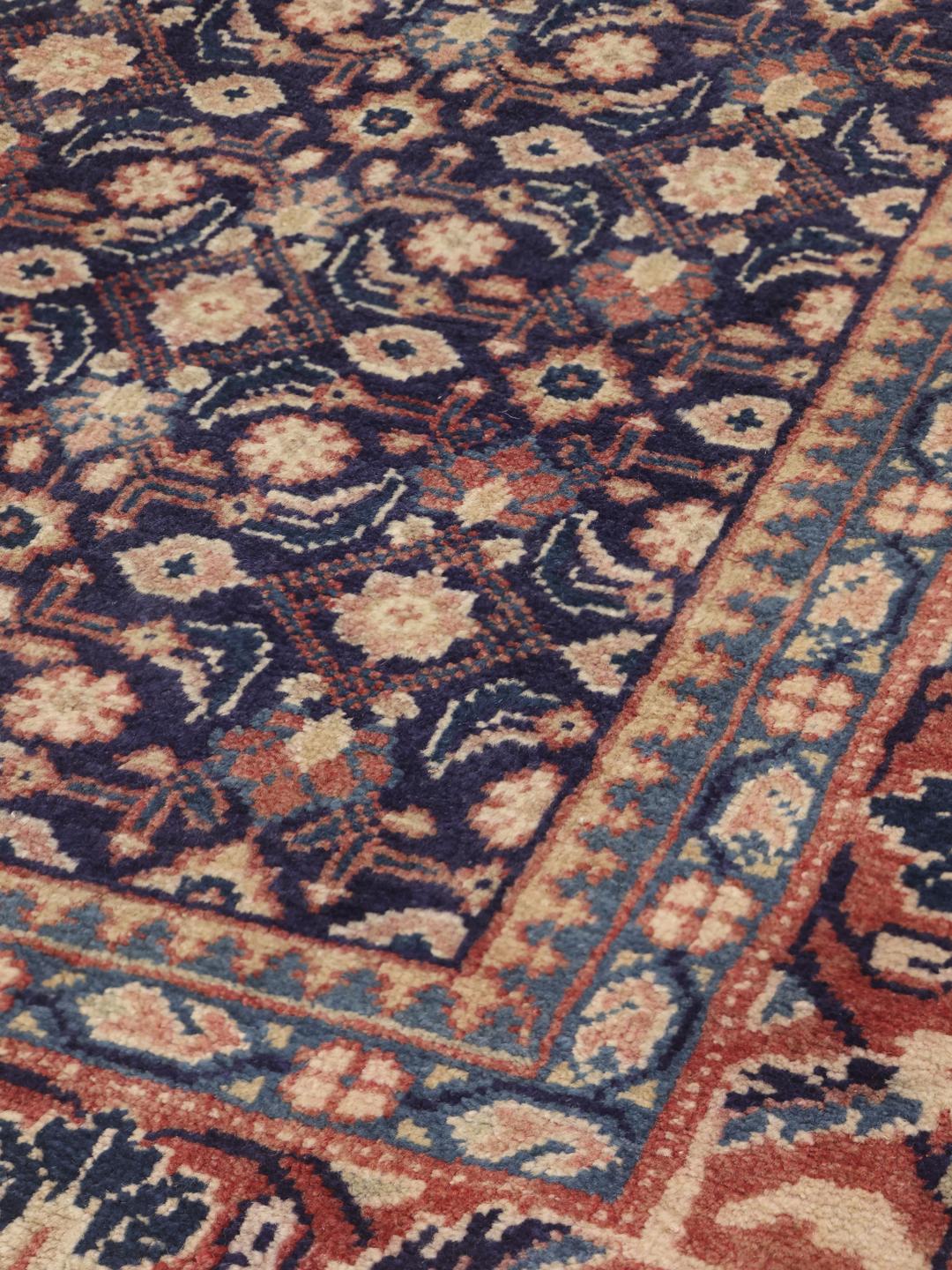 A hand-knotted Sarough rug from the Middle East with a deep blue floral pattern