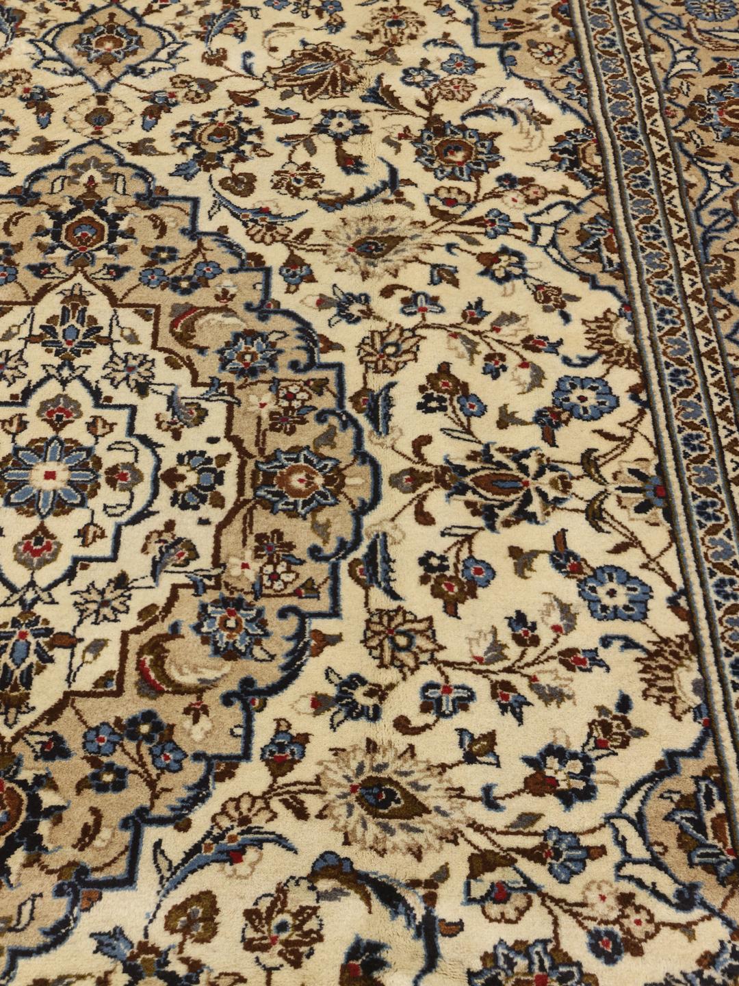 Handgeknoopt Keshan-tapijt uit het Midden-Oosten met een beige achtergrond en bloemenpatronen