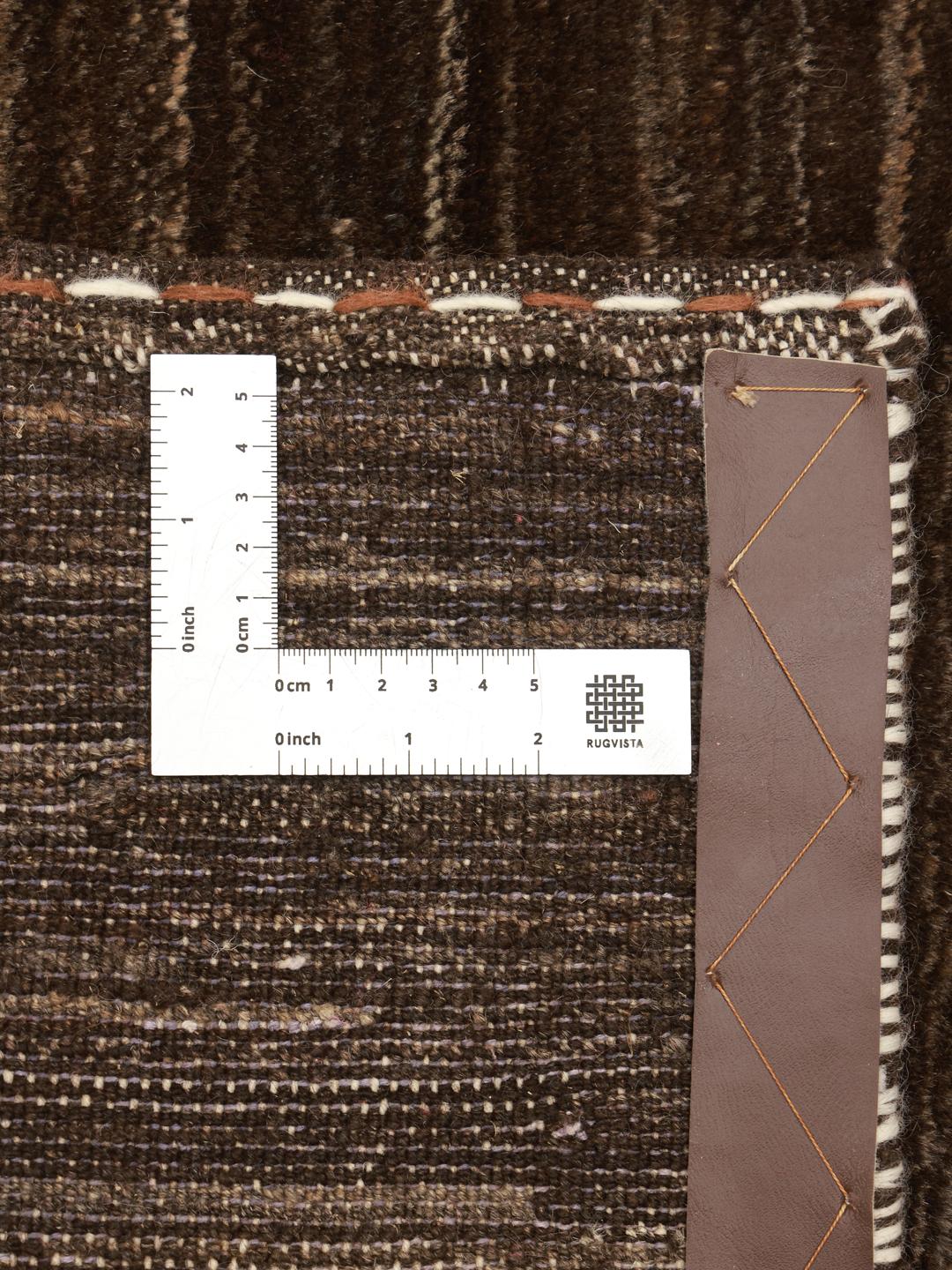Een handgeknoopt Gabbeh Fine tapijt uit het Midden-Oosten in een diepbruine tint.