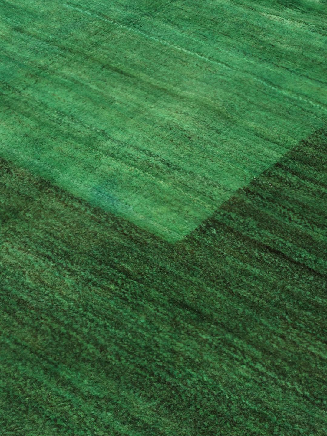 Hand-knotted Gabbeh rug from the Middle East in a deep green shade.