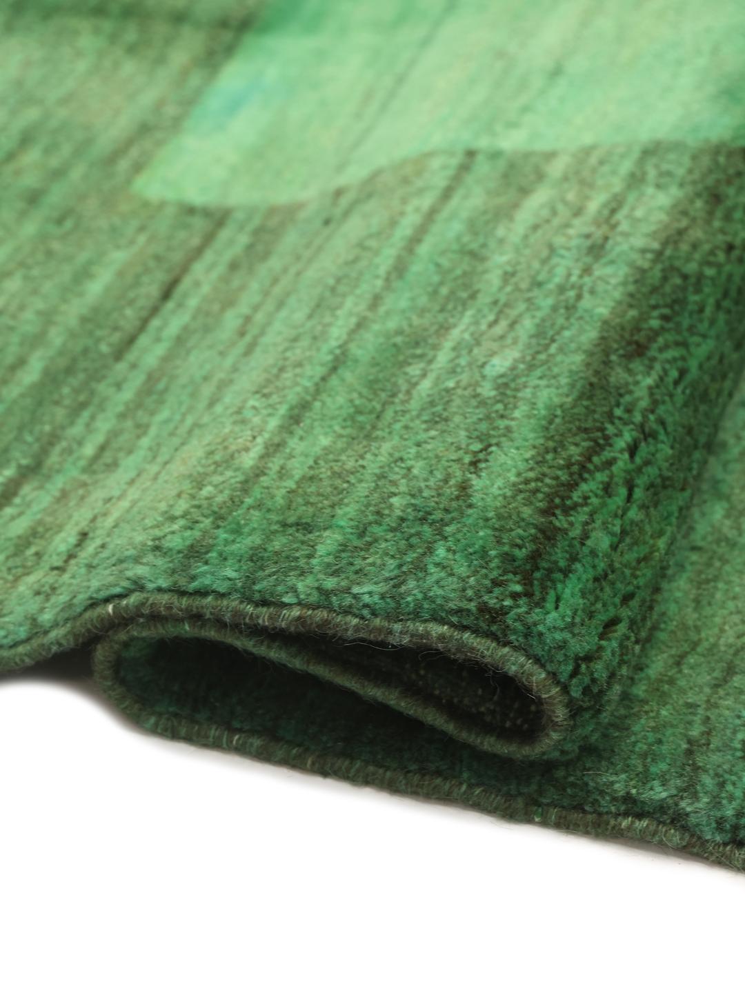Hand-knotted Gabbeh rug from the Middle East in a deep green shade.