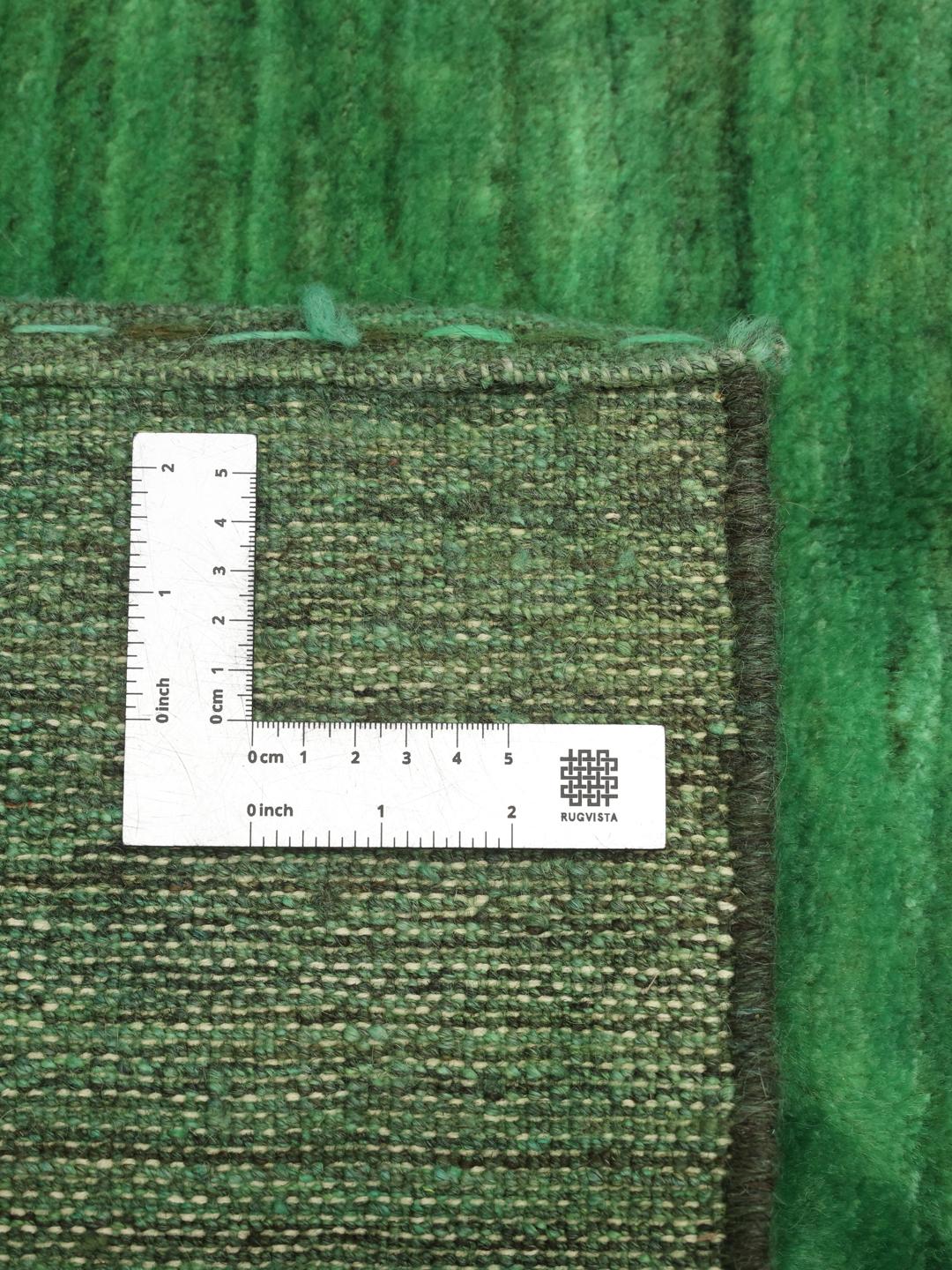 Hand-knotted Gabbeh rug from the Middle East in a deep green shade.