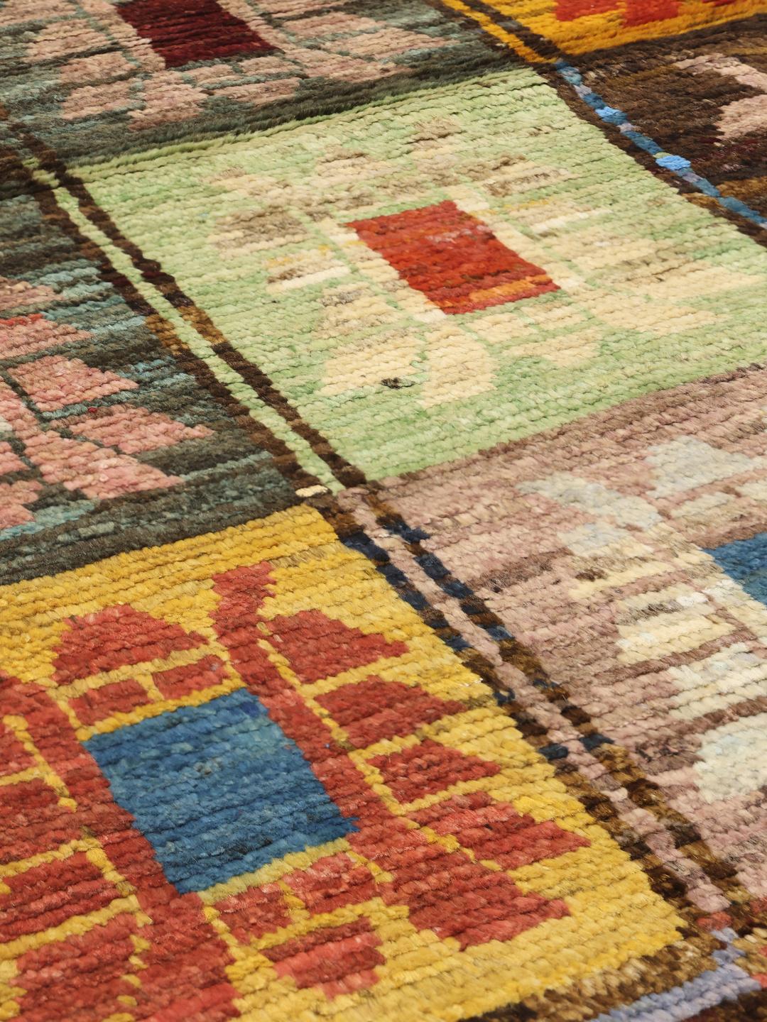 Een levendige, handgeknoopte loper uit Afghanistan met een kleurrijk raster van decoratieve motieven.