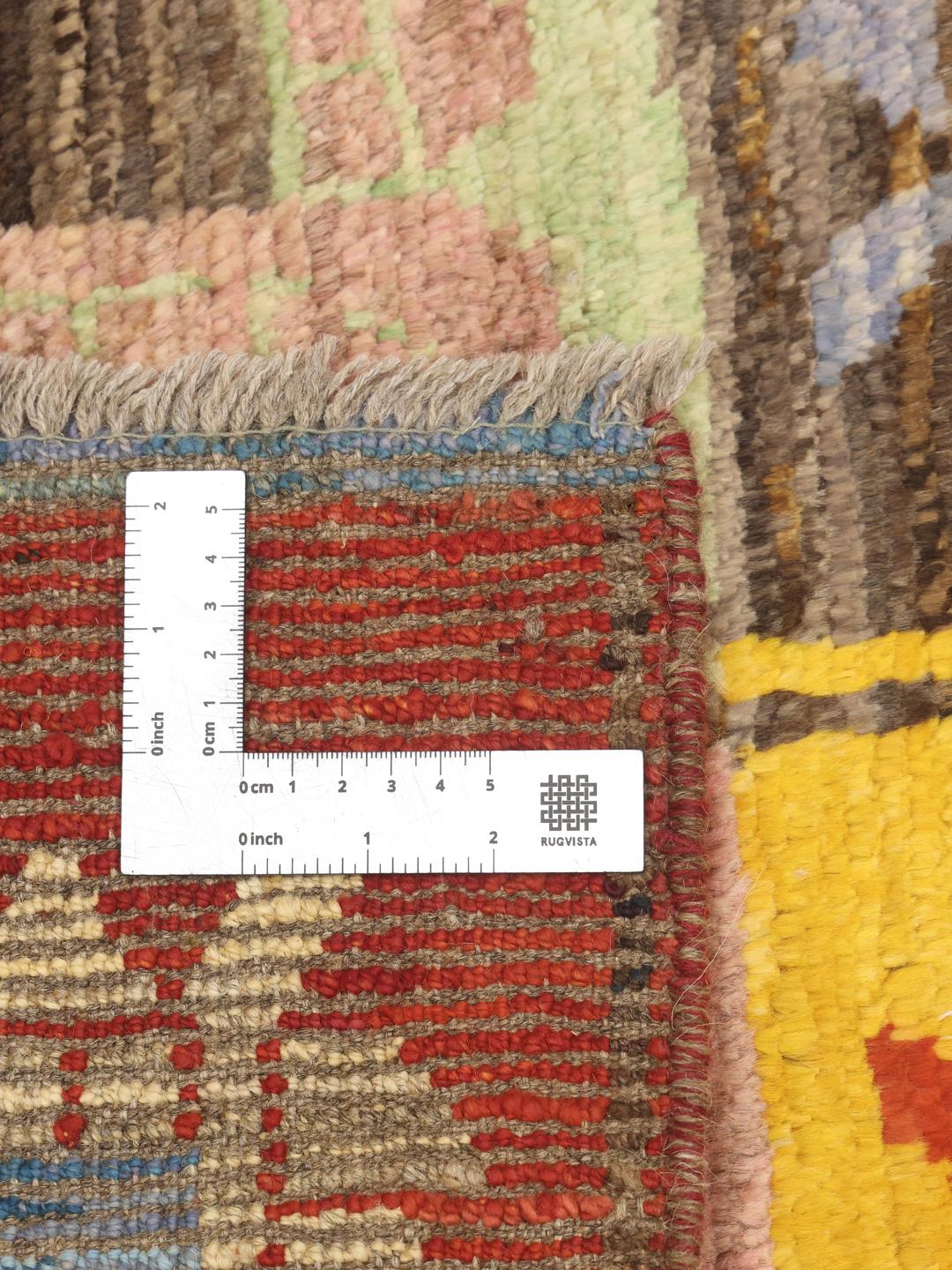 Een levendige, handgeknoopte loper uit Afghanistan met een kleurrijk raster van decoratieve motieven.