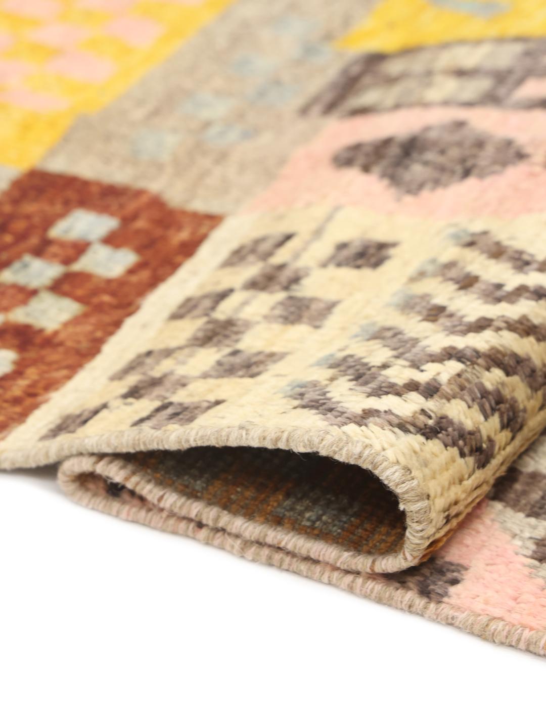 Et levende, håndknyttet Berber-tæppe fra Afghanistan med et farverigt, geometrisk patchwork-design.