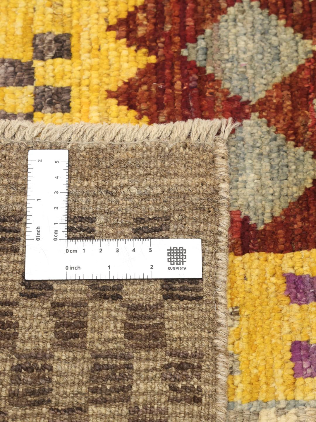 Et levende, håndknyttet Berber-tæppe fra Afghanistan med et farverigt, geometrisk patchwork-design.