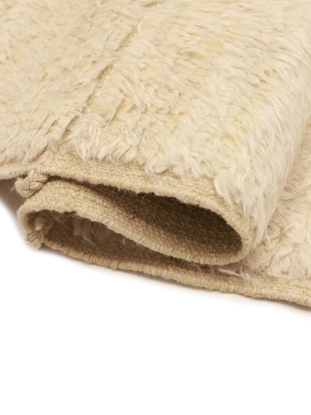 A neutral, hand-knotted beige rug from Afghanistan with an organic, minimalist design.