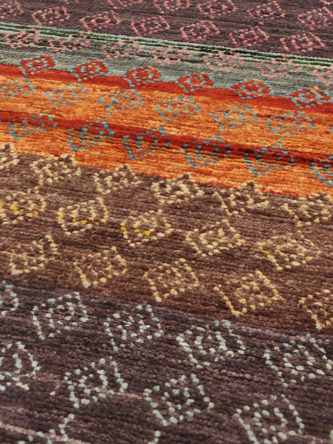 Handgeknoopt Afghaans tapijt met levendige geometrische patronen in veelkleurige wol.