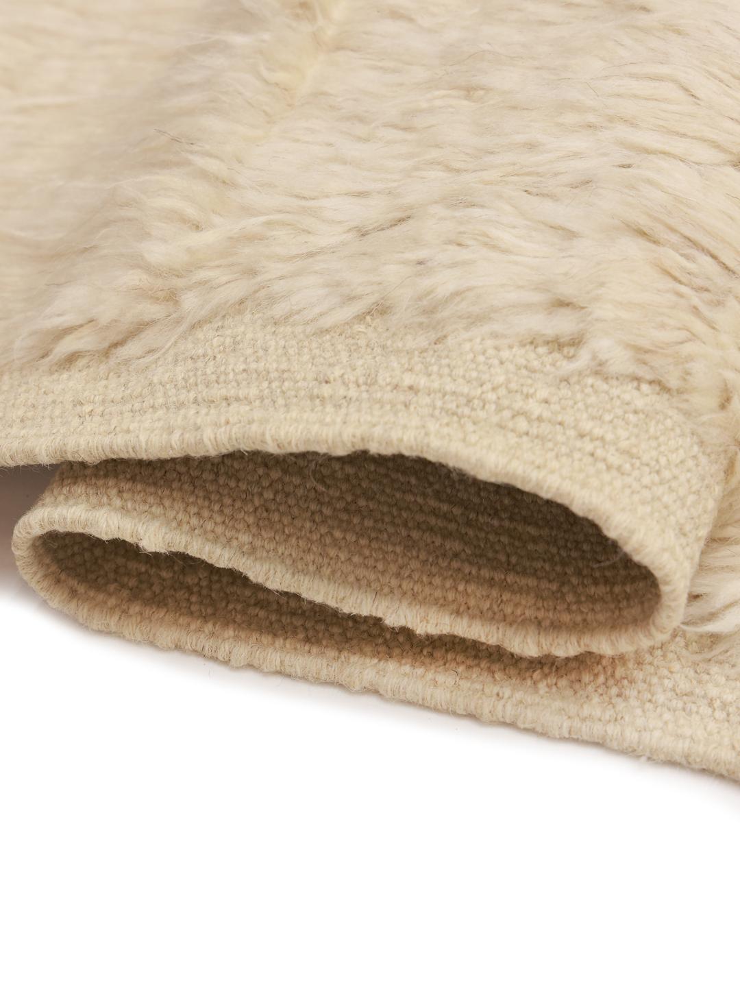Tapis afghan noué à la main dans un ton beige neutre avec de subtiles lignes géométriques.